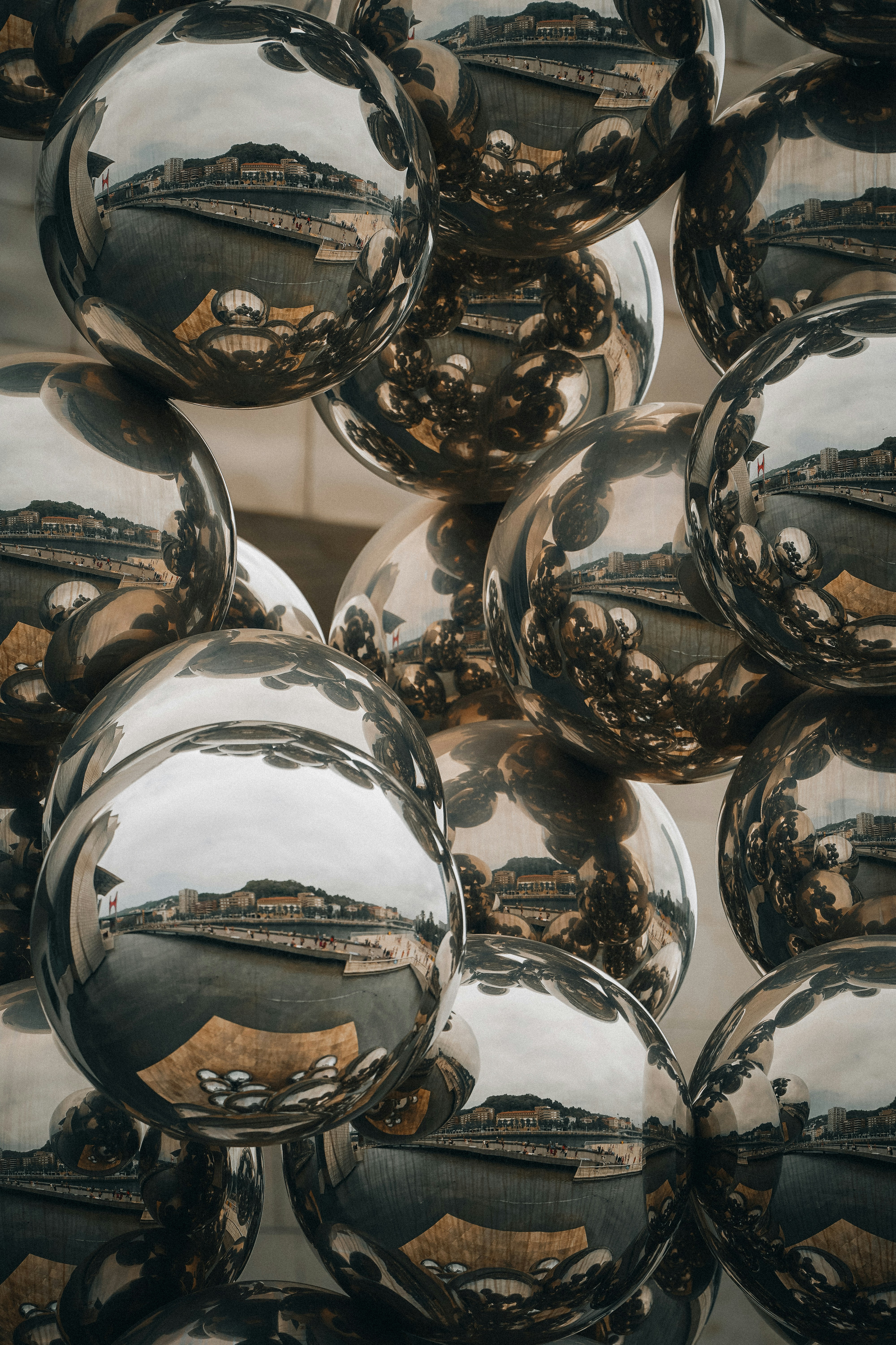 Shiny silver spheres reflecting buildings and sky