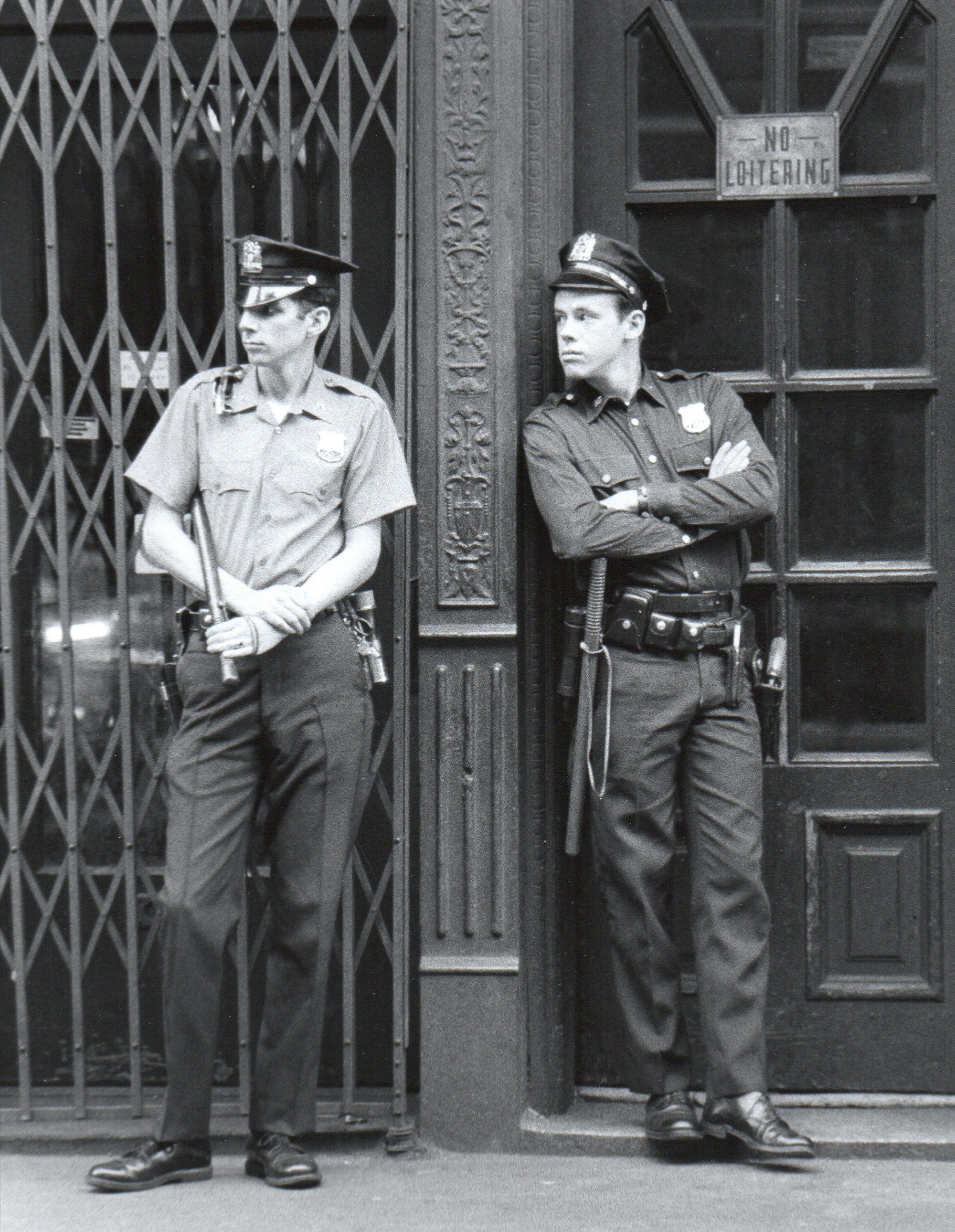 Two police officers stand guard outside a building.