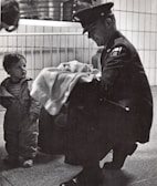 Soldier offers blanket to a child