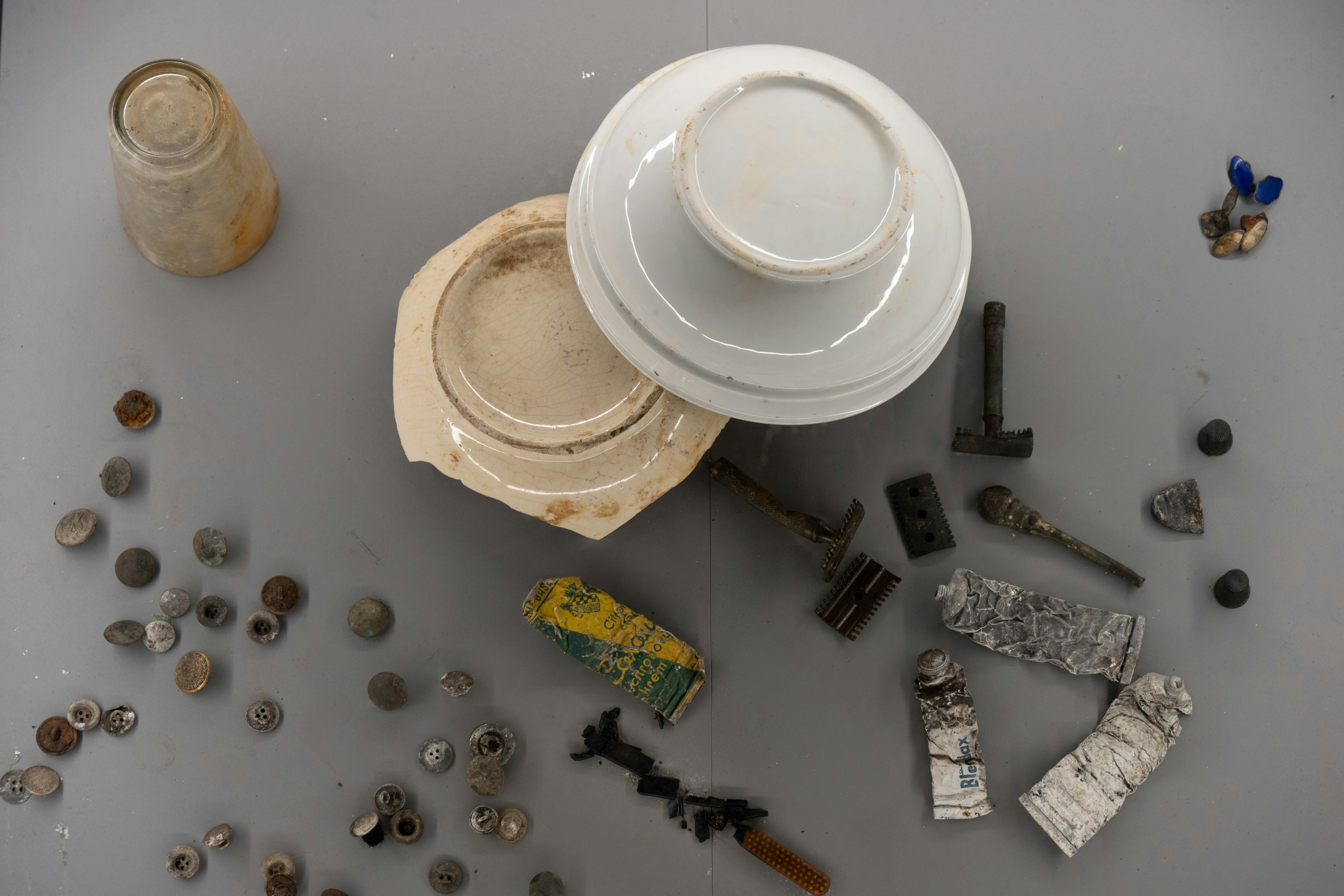 灰色の表面に歴史的遺物や陶器の破片の品揃え
