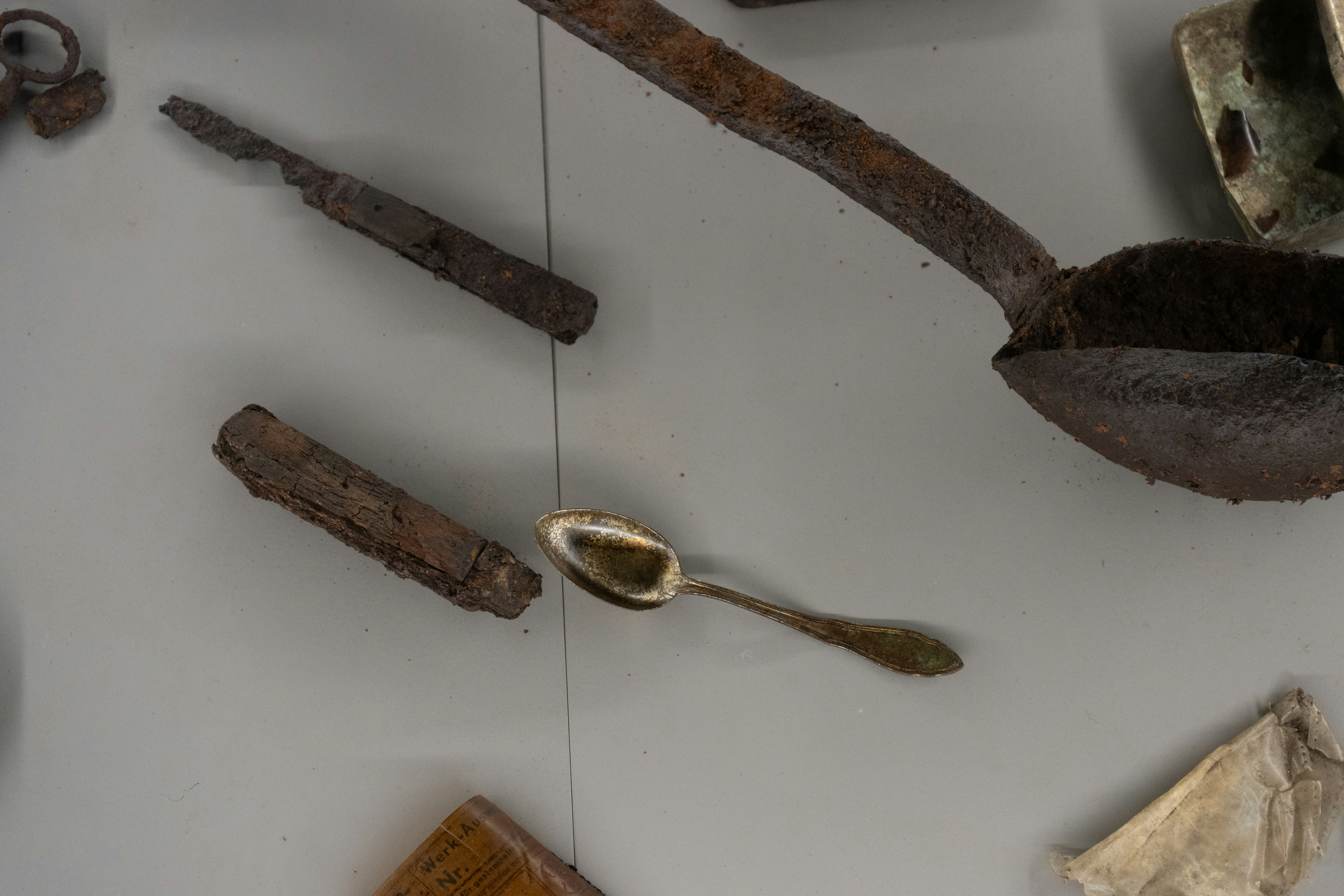 Antique cutlery and utensils displayed on a gray surface.