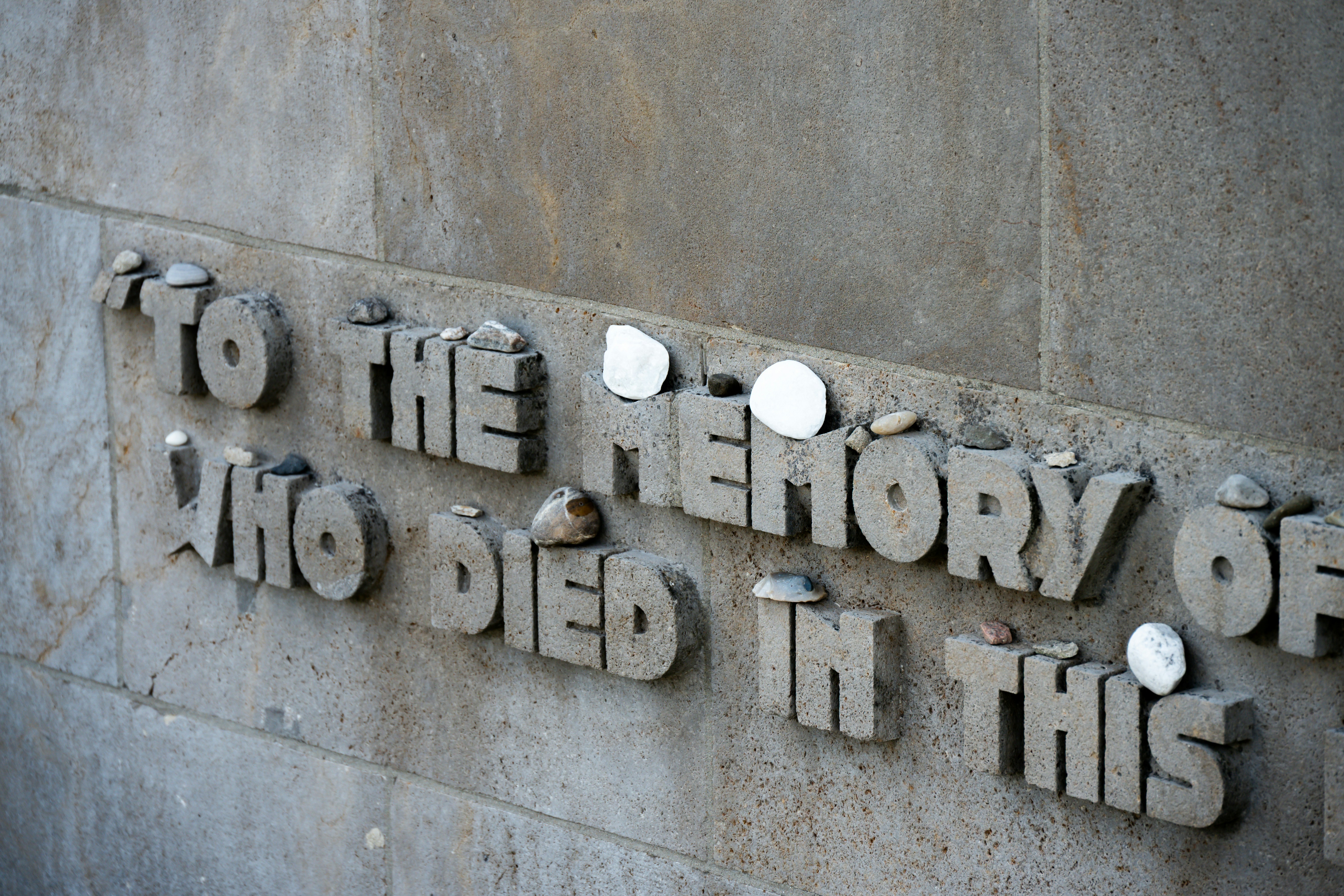 Text on a stone wall in memory of those who died.