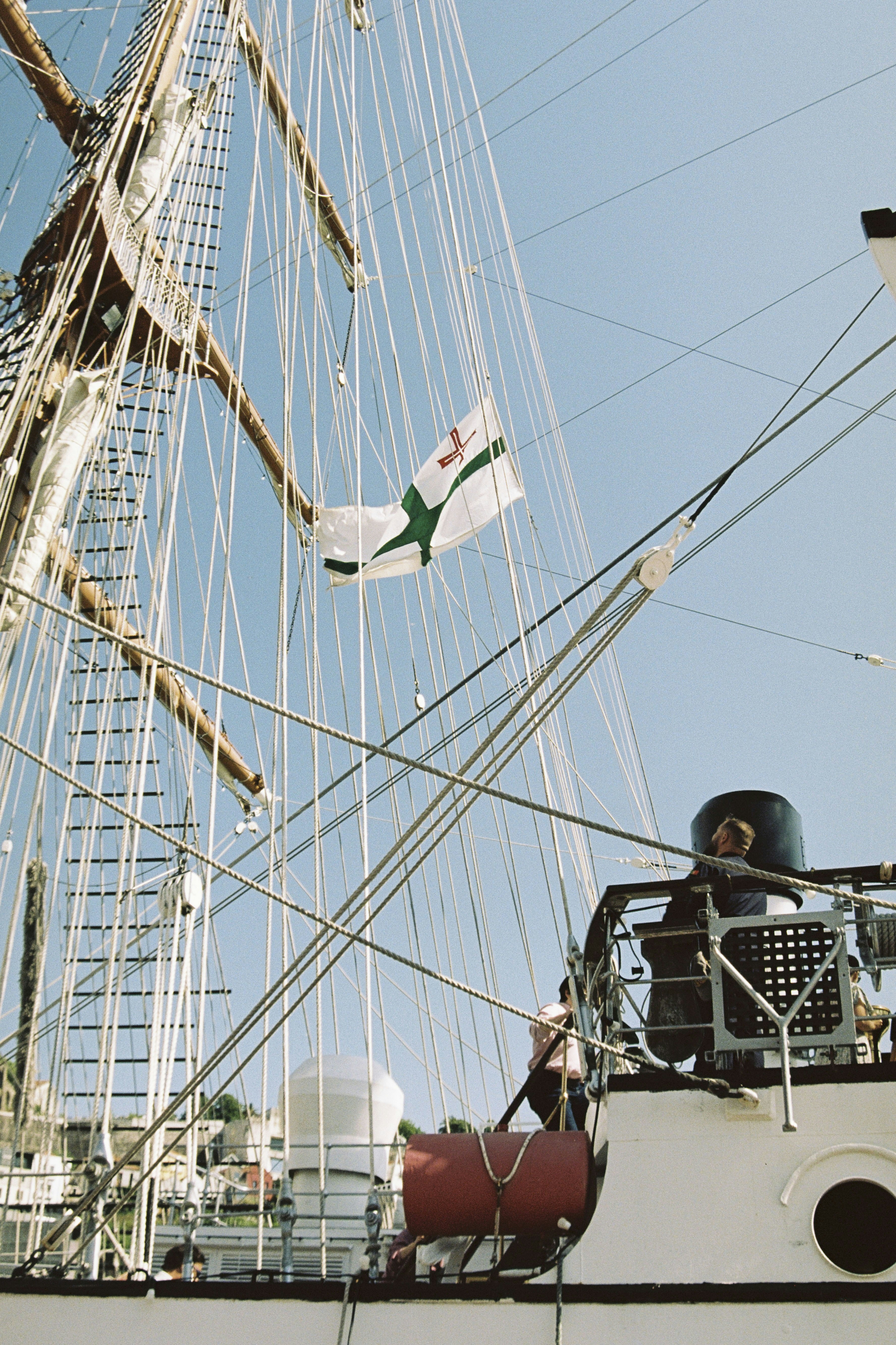Tall ship with white sails and rigging against blue sky
