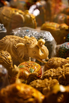 Collection of ornate elephant figurines and decorative boxes.