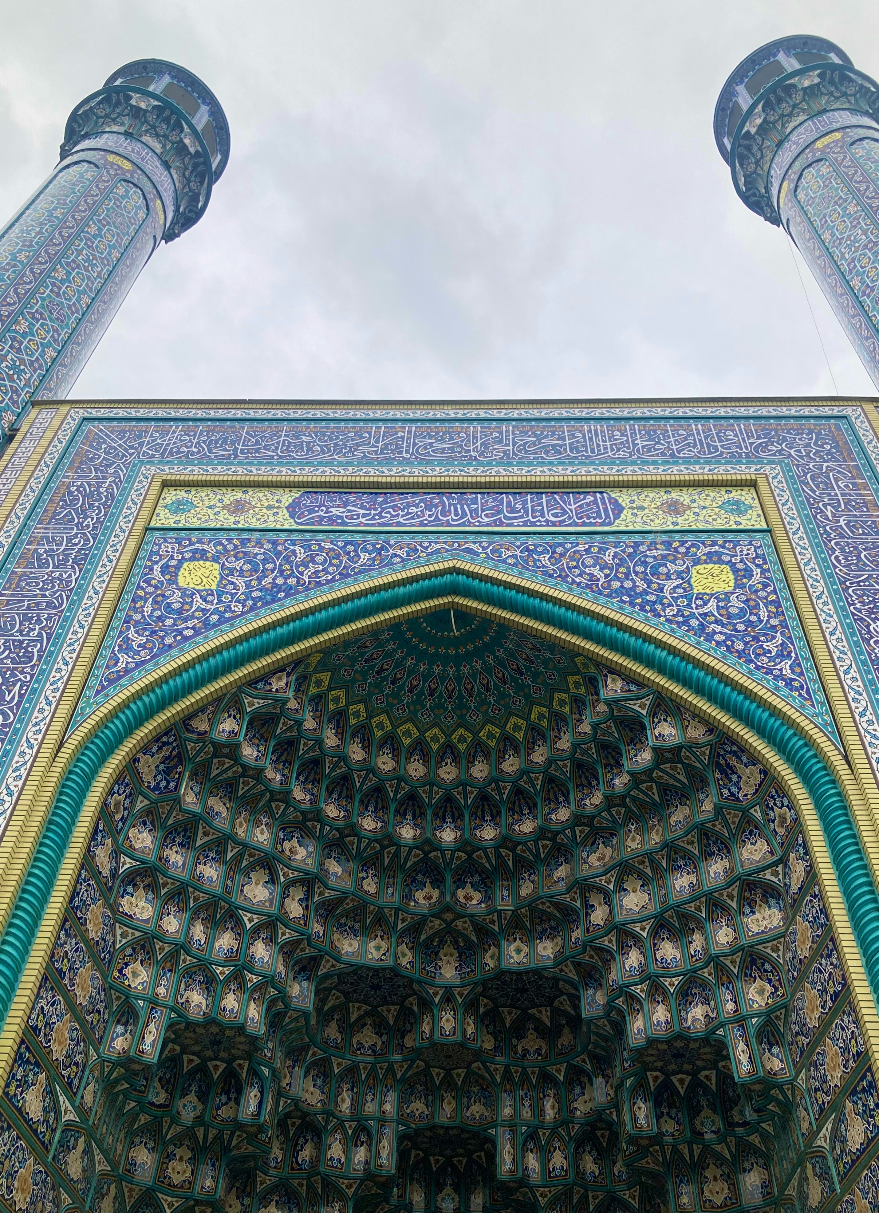 Ornate mosque entrance with intricate blue tilework and towers