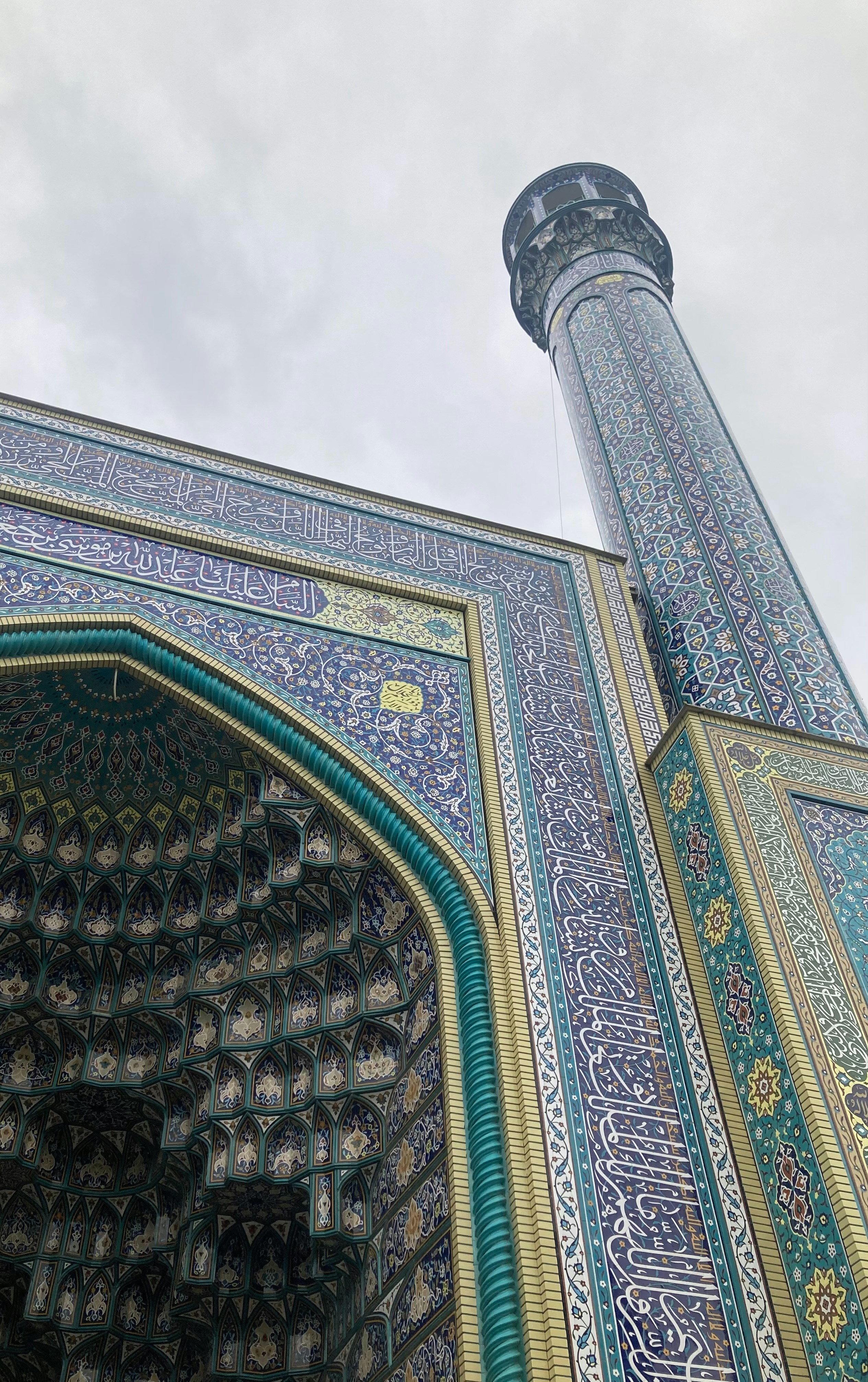 Intricate tilework adorns a mosque minaret and entrance.
