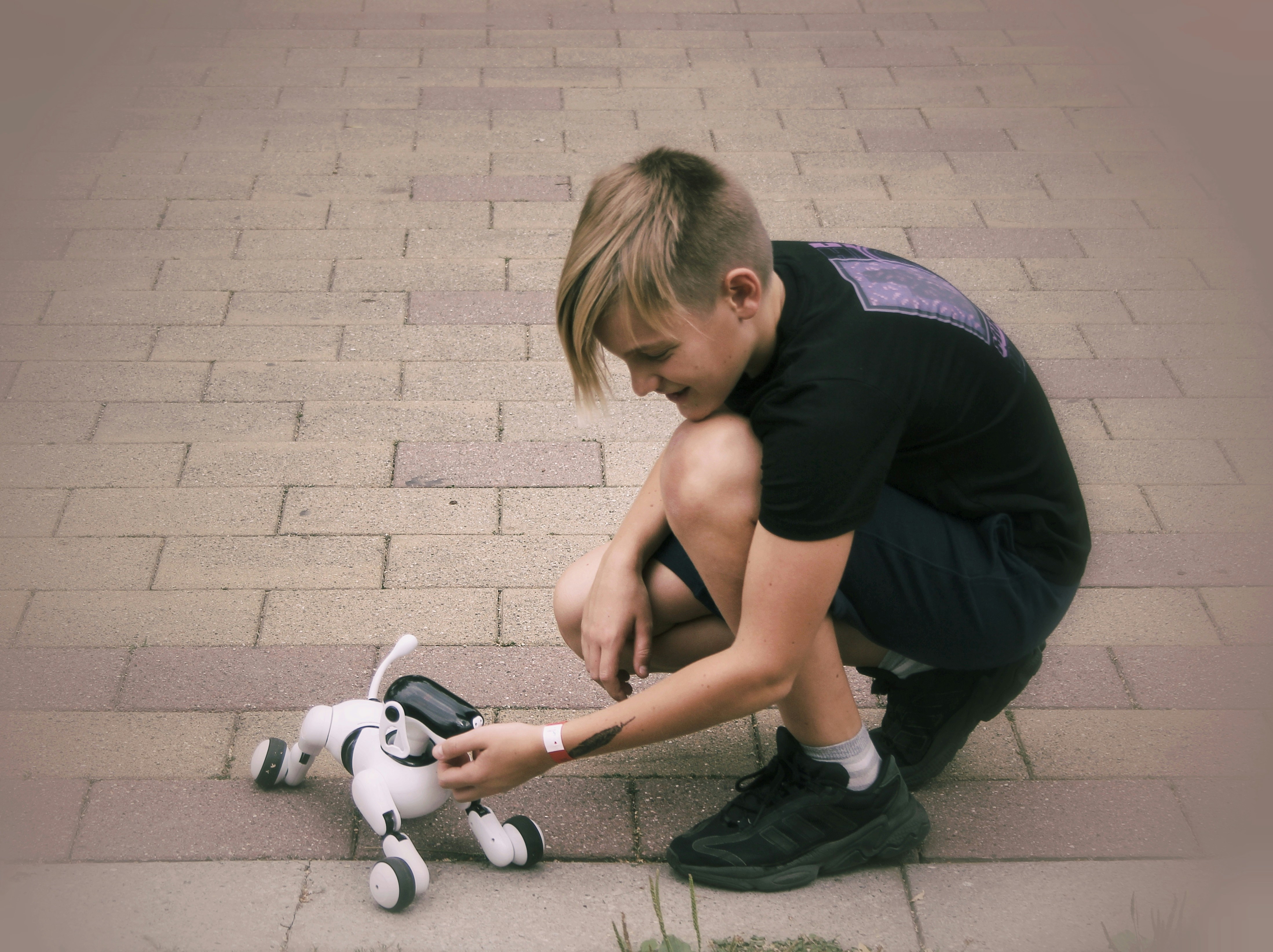 Young boy playing with a robot dog outside
