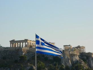 Greek flag waving with the acropolis in the background