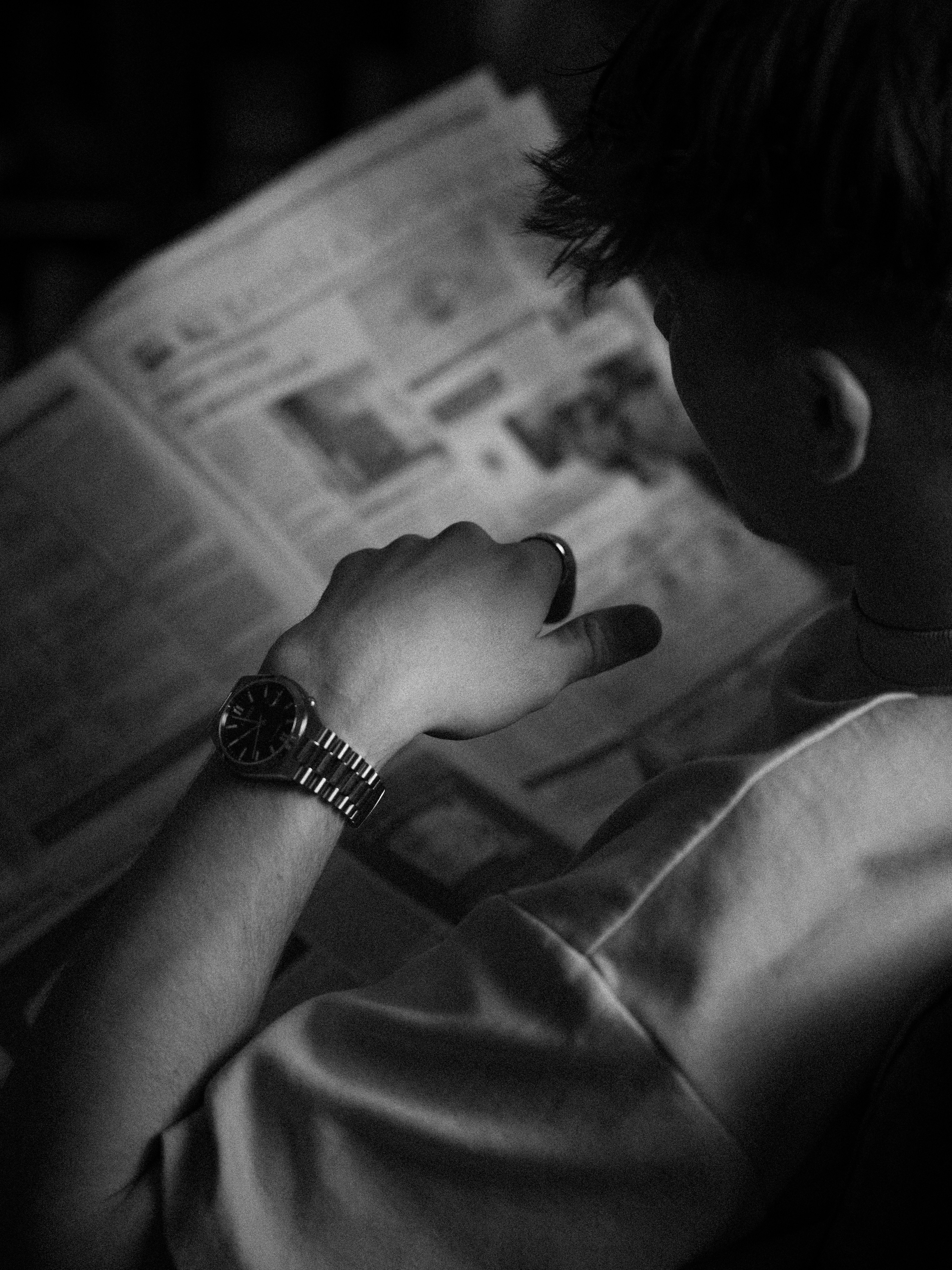 Person, die eine Uhr trägt, liest eine Zeitung