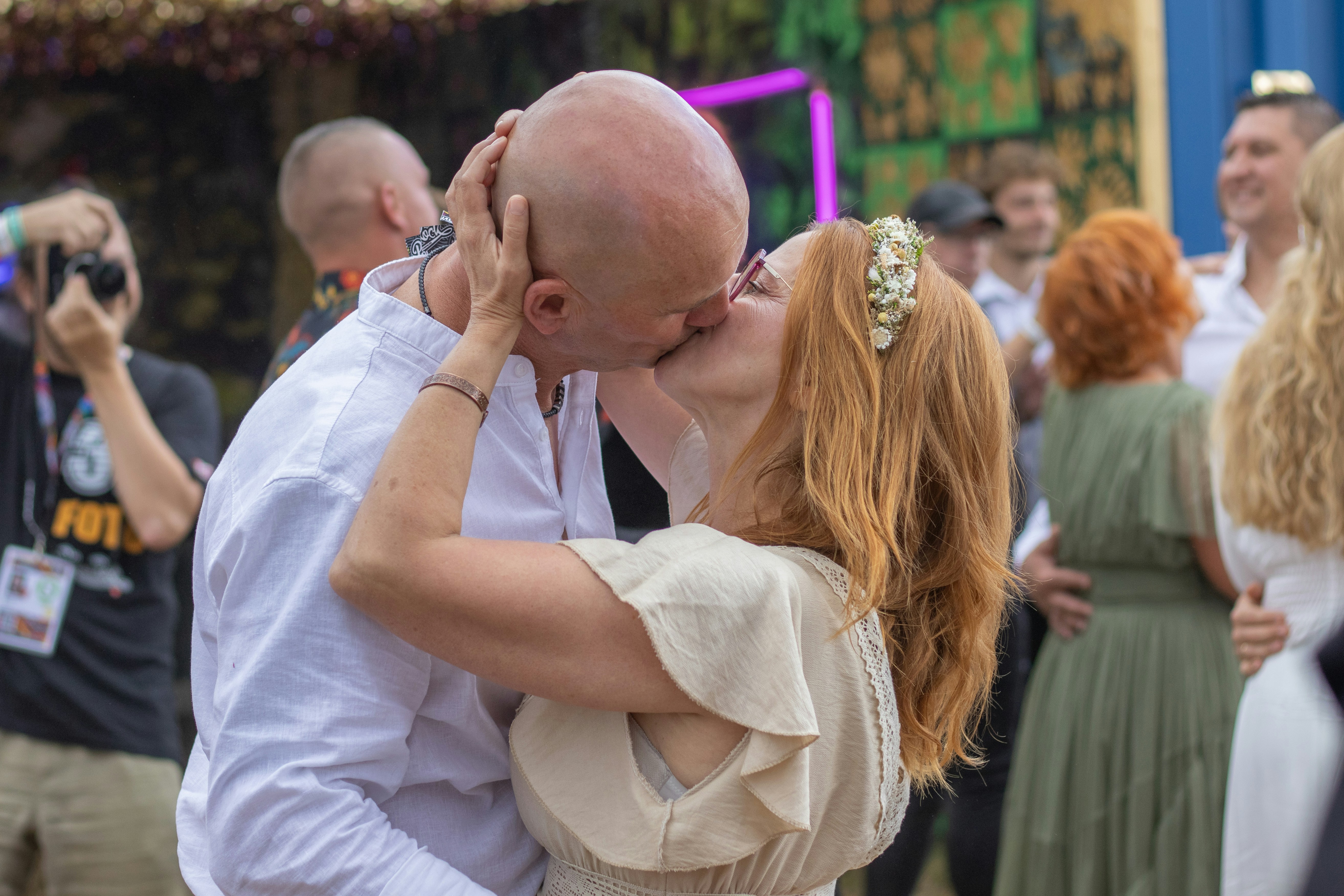 Couple kissing passionately at an outdoor event.