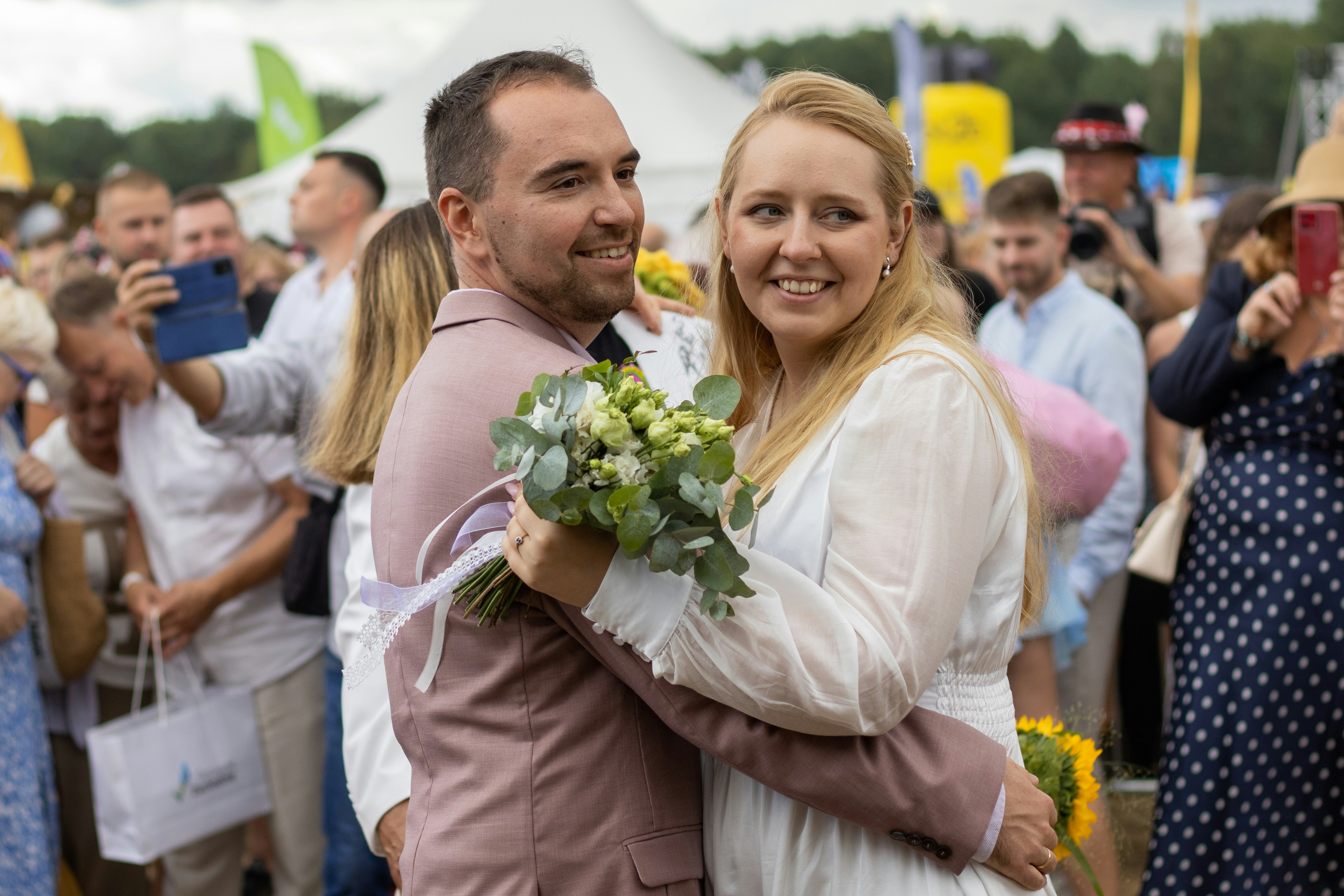Couple holding bouquet at outdoor wedding ceremony