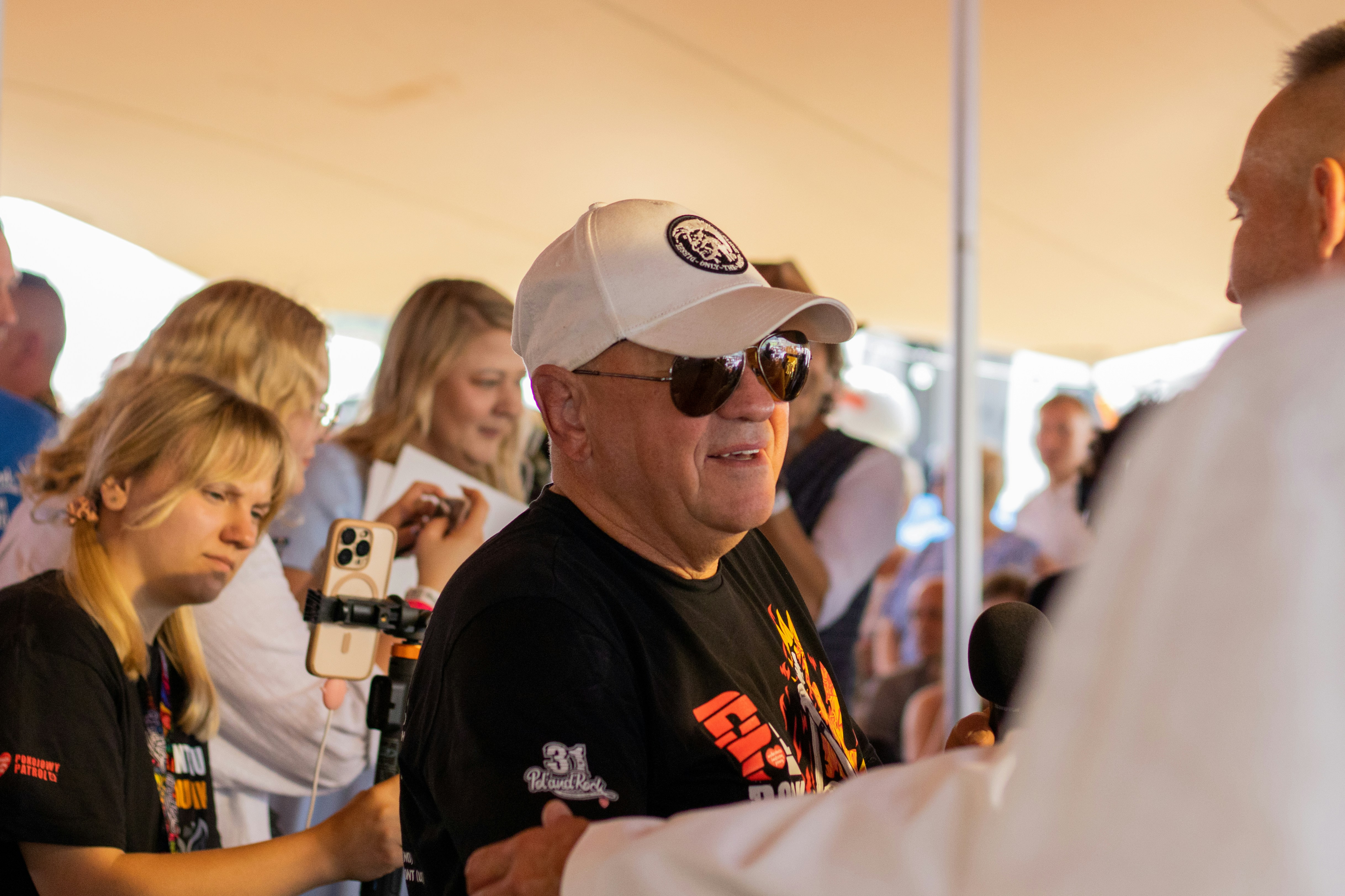 Man in baseball cap and sunglasses talking