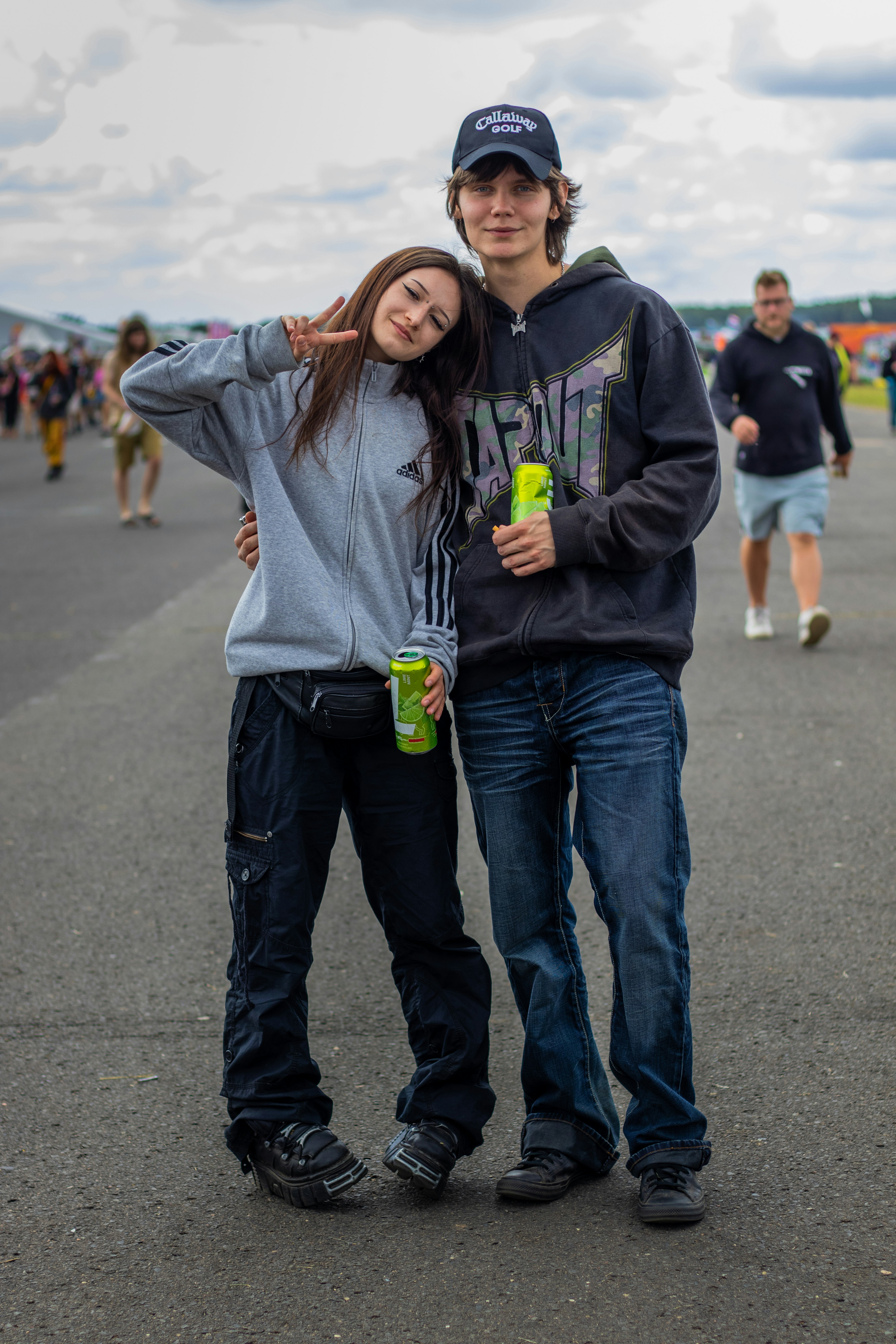 Young couple posing together outdoors with drinks