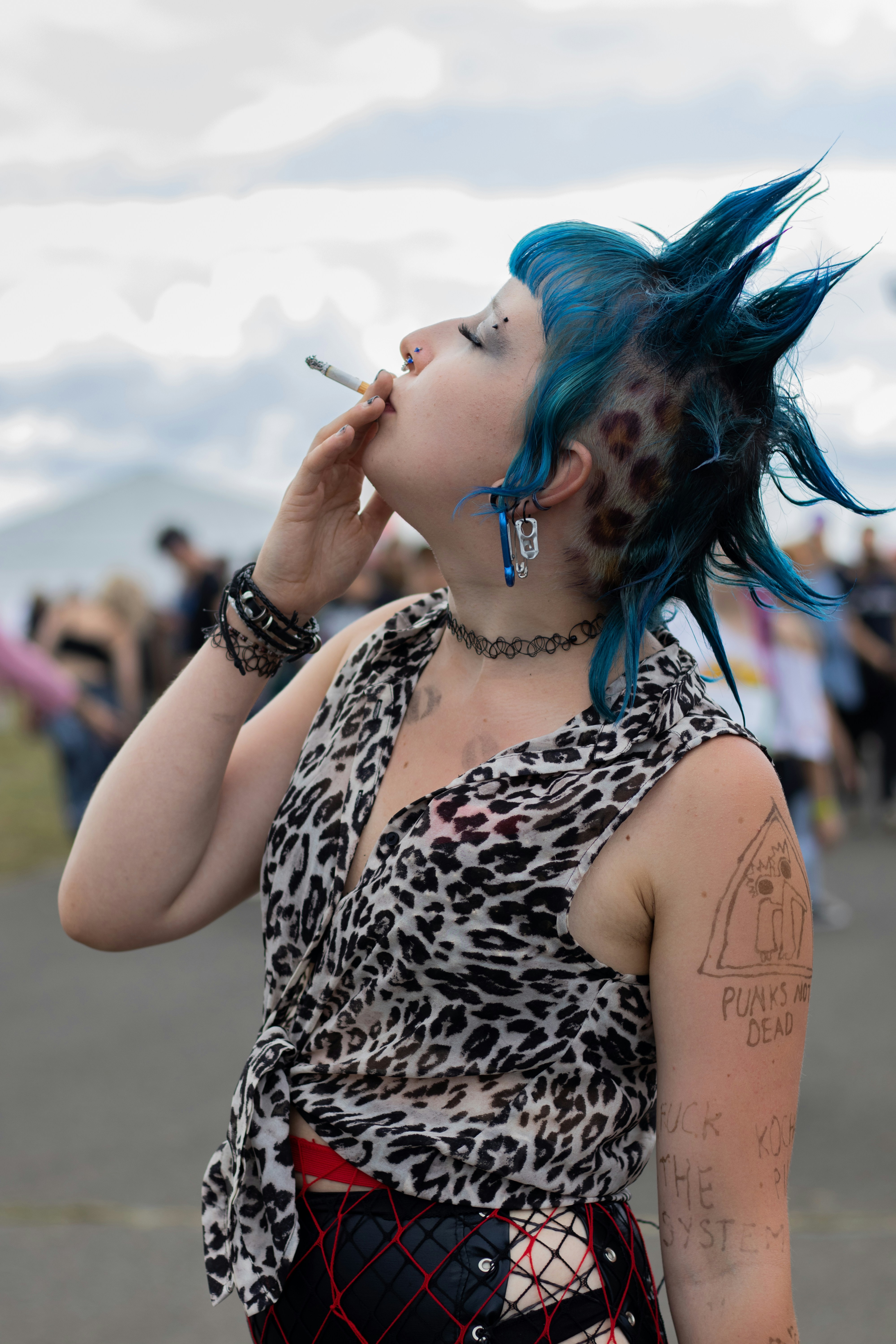 Woman with blue mohawk smoking cigarette