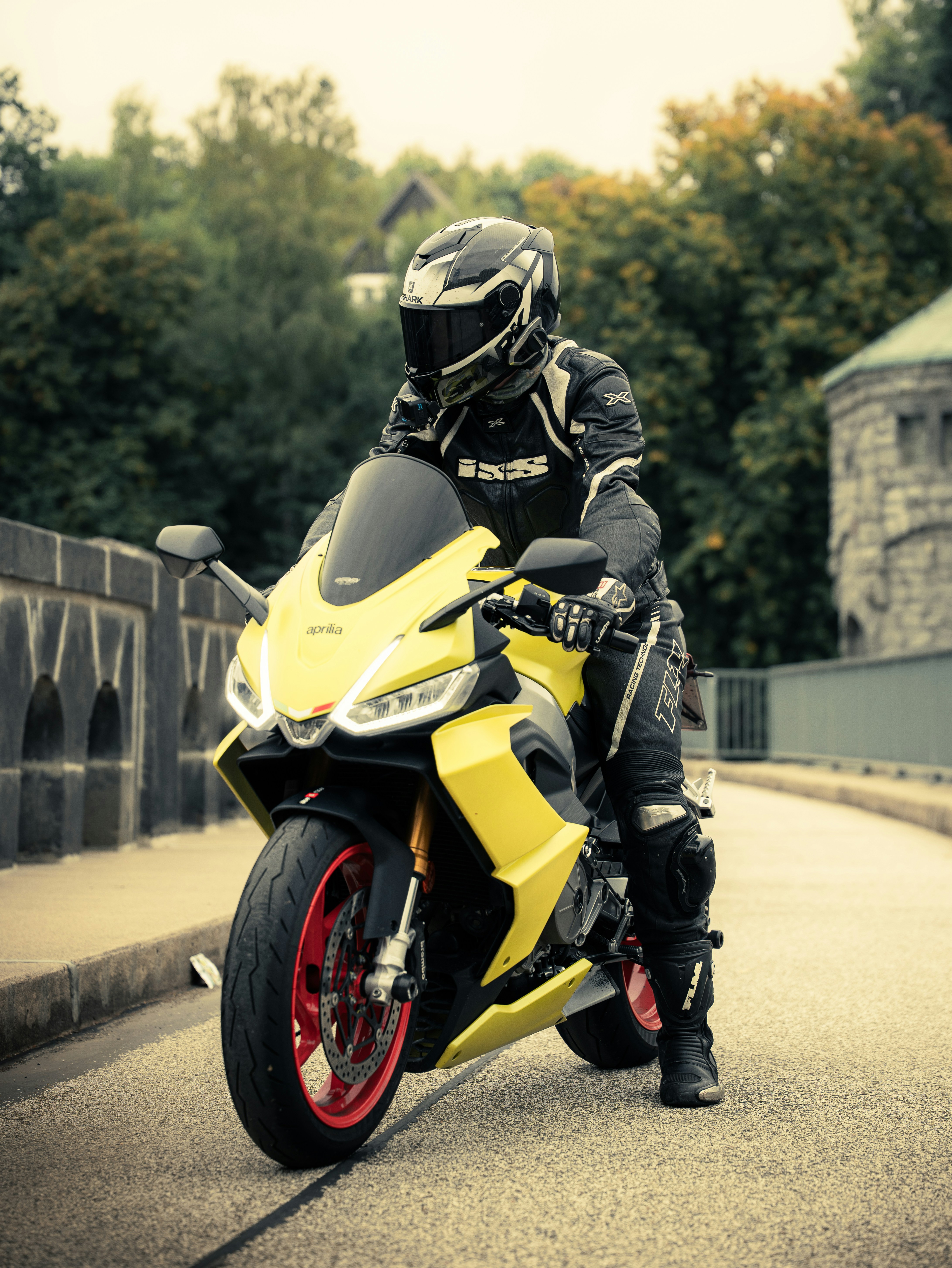 Gelbes Motorrad mit Fahrer auf einer Brücke