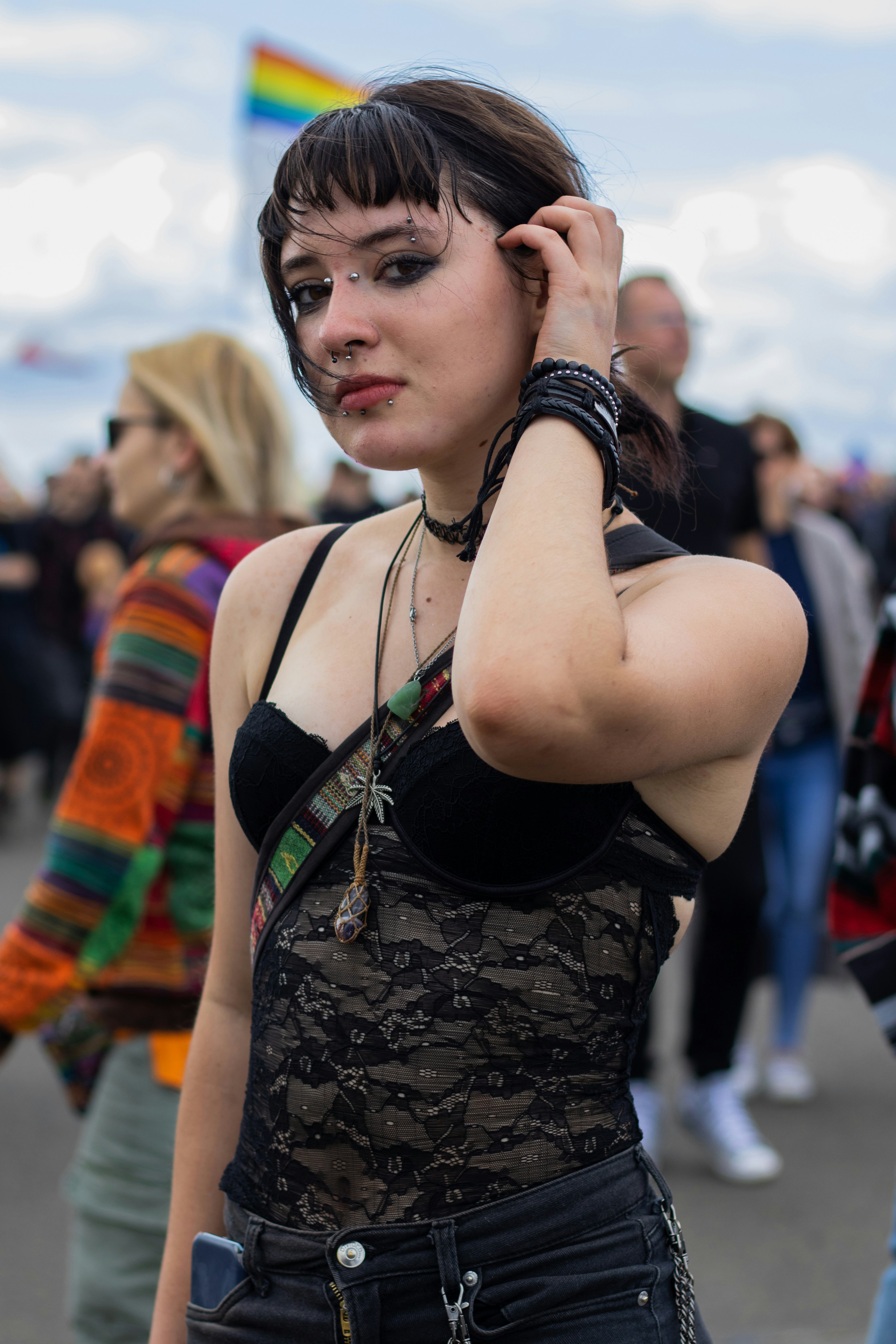 Young woman with dark hair and makeup adjusts her hair
