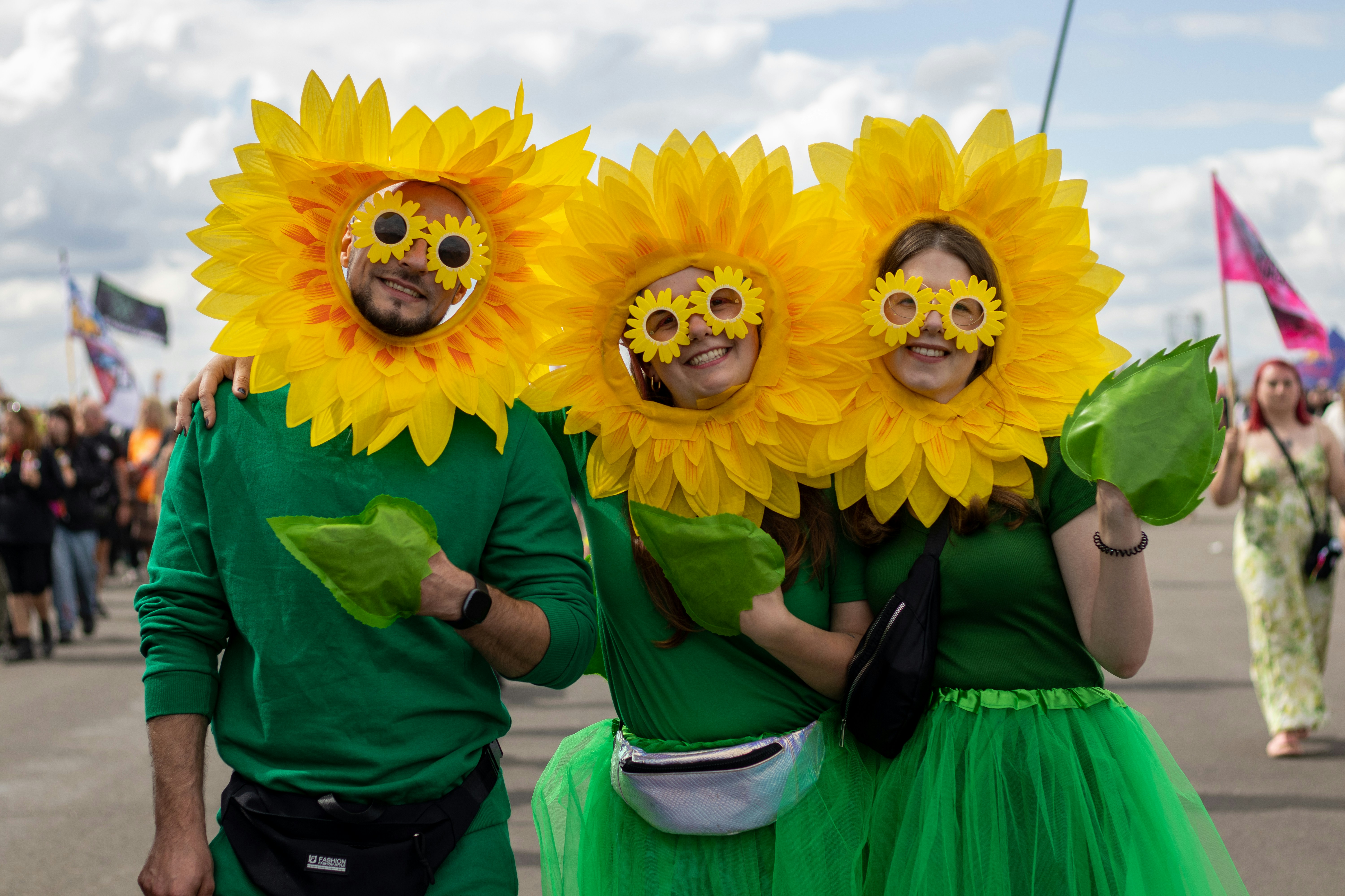 Three people in sunflower costumes smiling