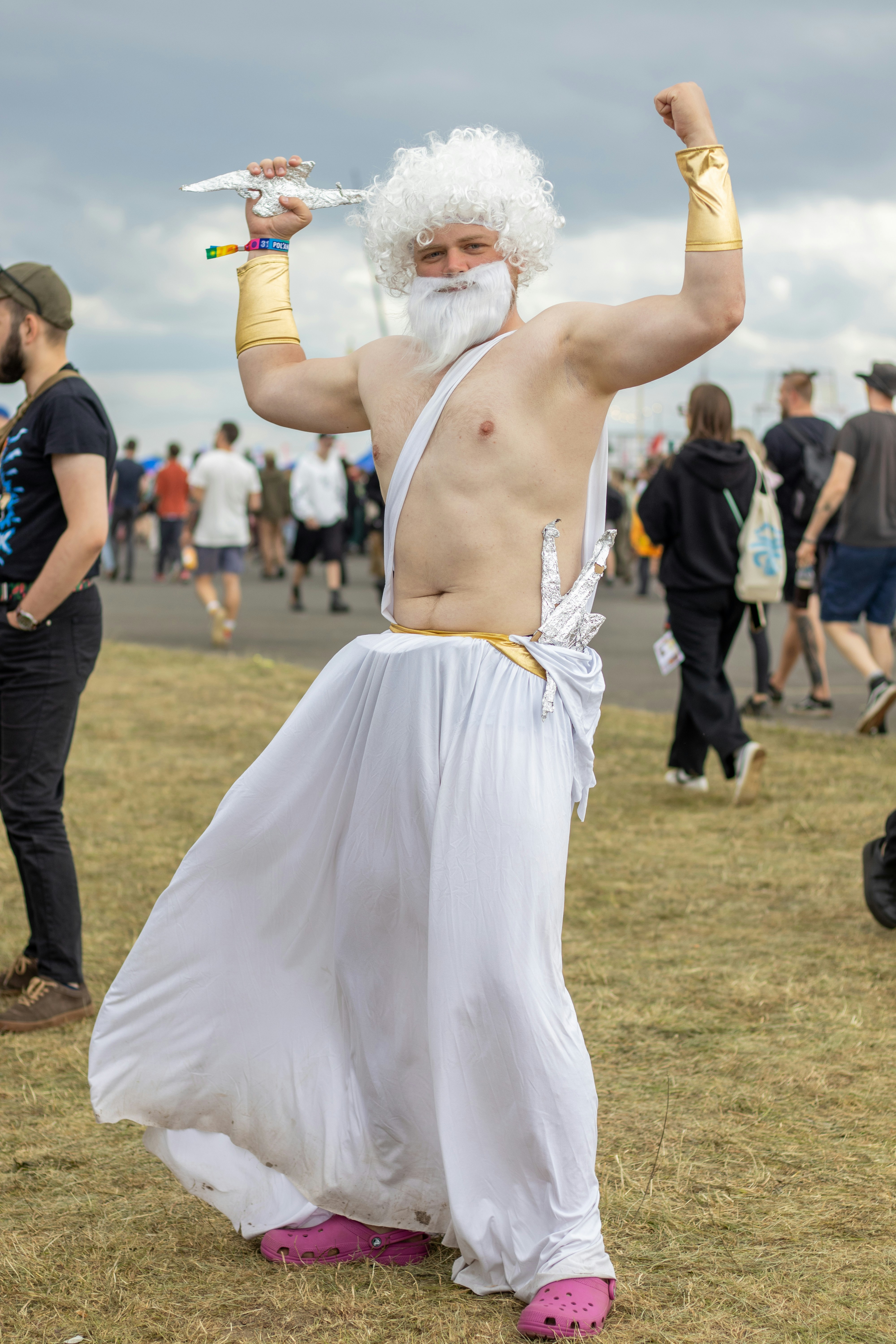 Man dressed as zeus holding a lightning bolt