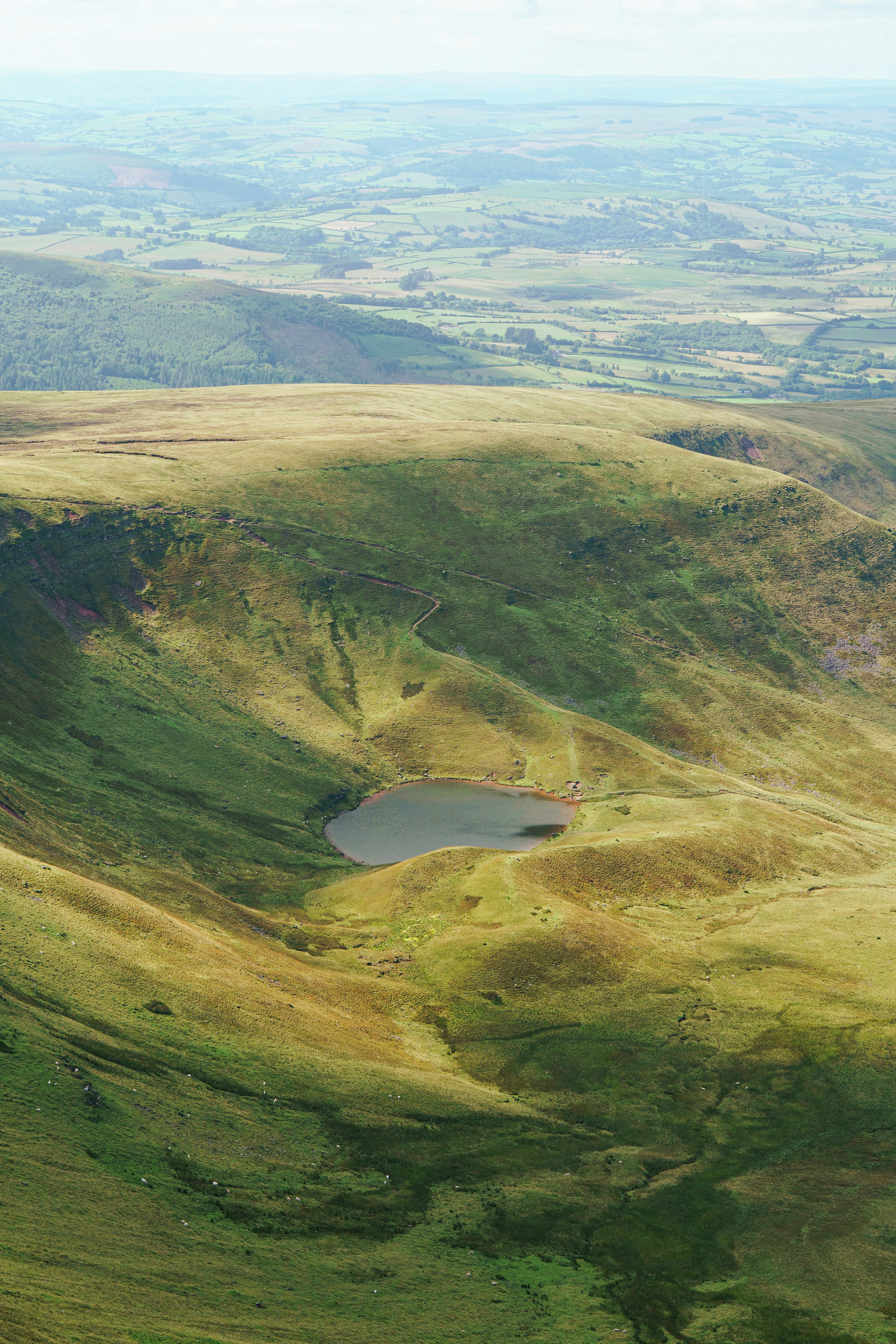 A small lake nestled in a green mountain valley.