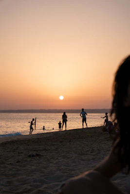Silhouettes of people enjoying a beach sunset