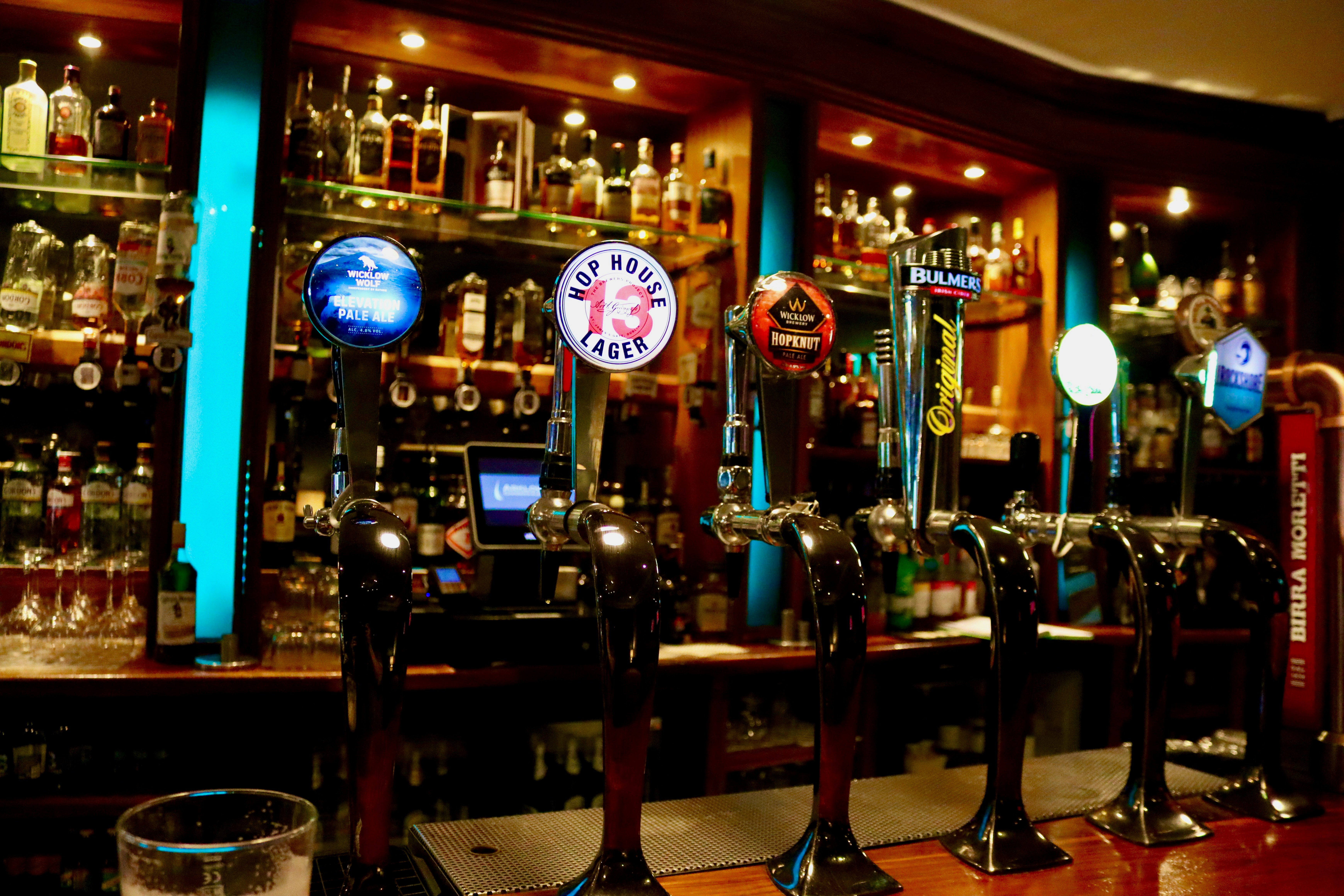 A row of beer taps at a bar