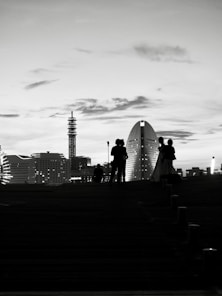 Silhouettes of people against a city skyline at dusk
