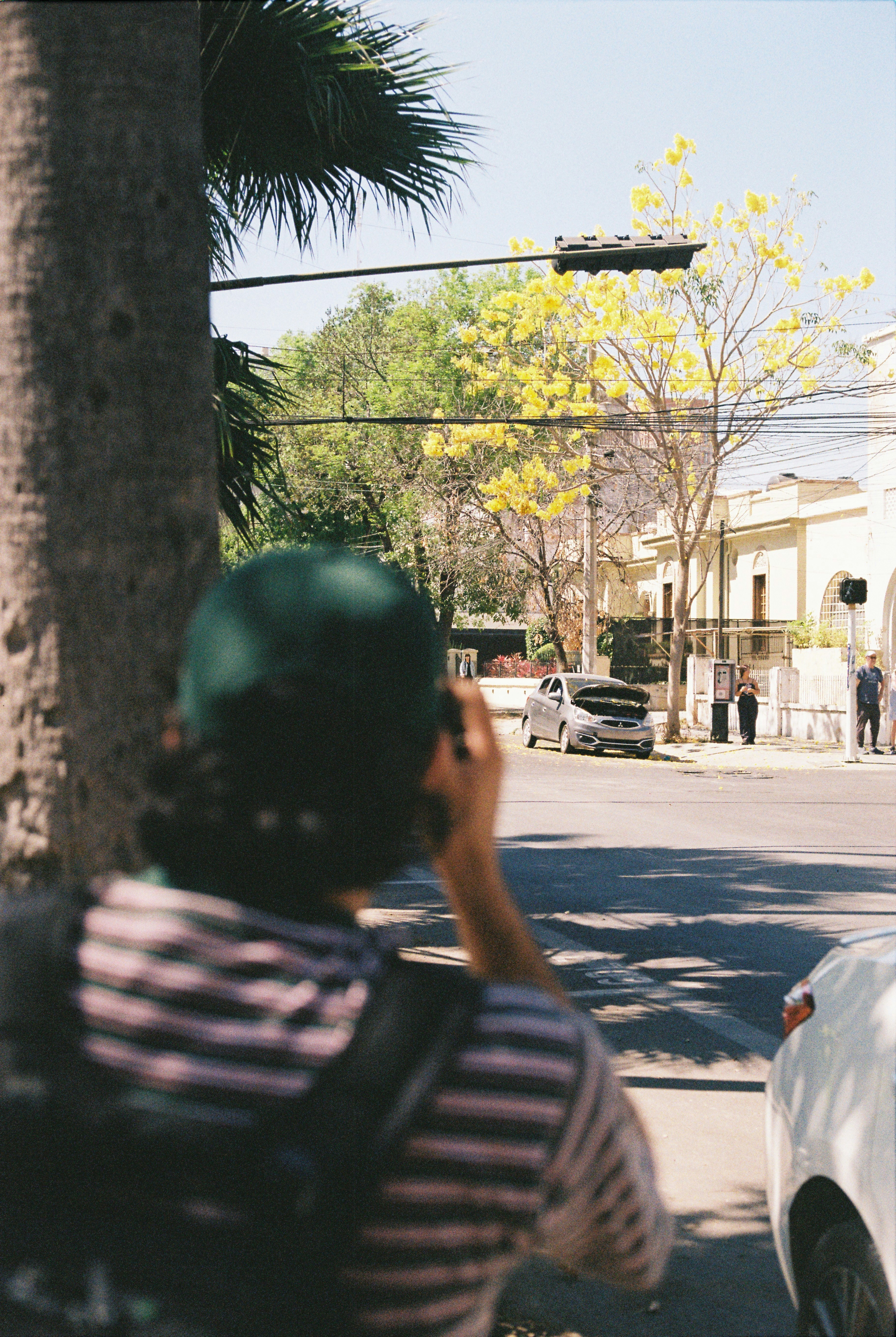 초록색 모자를 쓴 사람이 거리 사진을 찍고 있습니다.