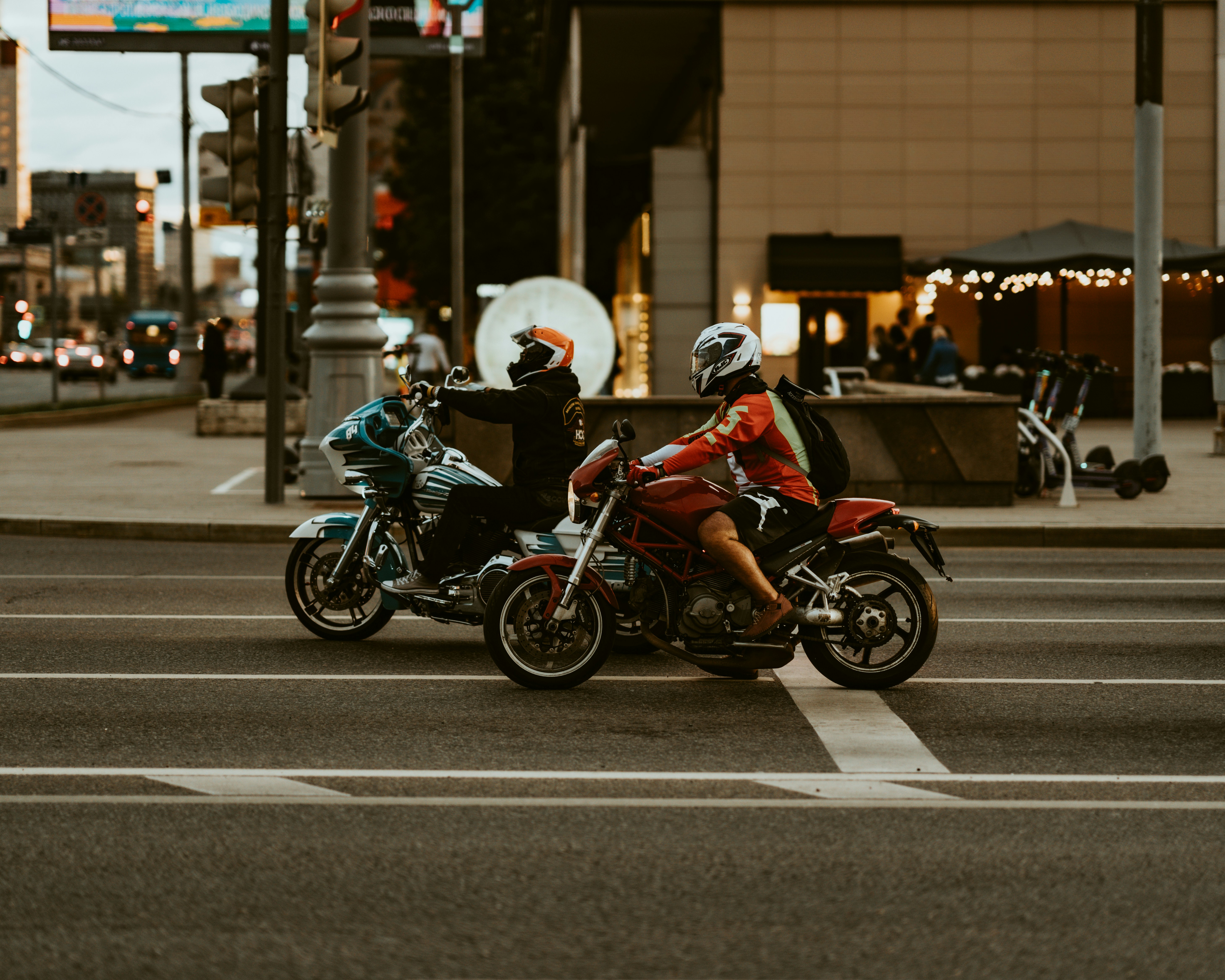 Two motorcyclists riding on a city street