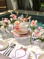A beautifully decorated cake table with flowers and candles.