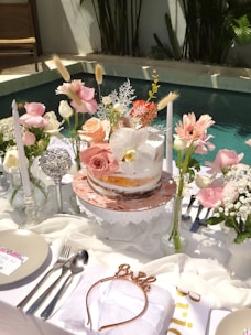 A beautifully decorated cake table with flowers and candles.