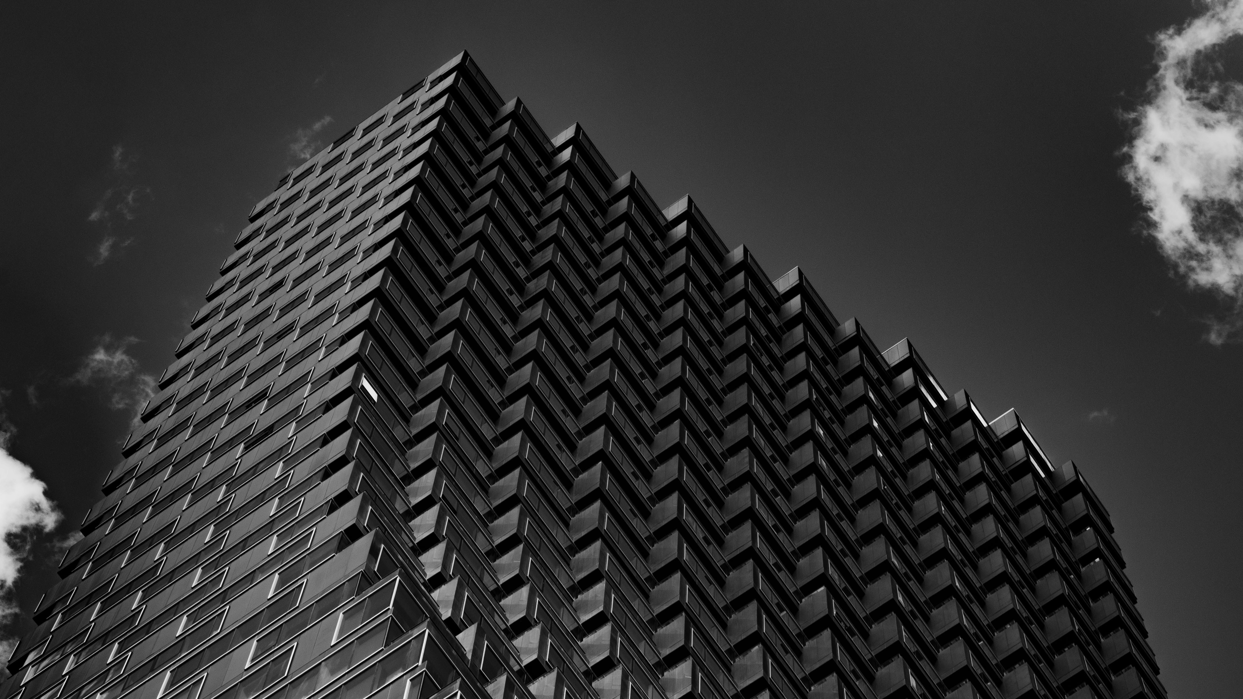 Modern skyscraper with zigzag facade against cloudy sky