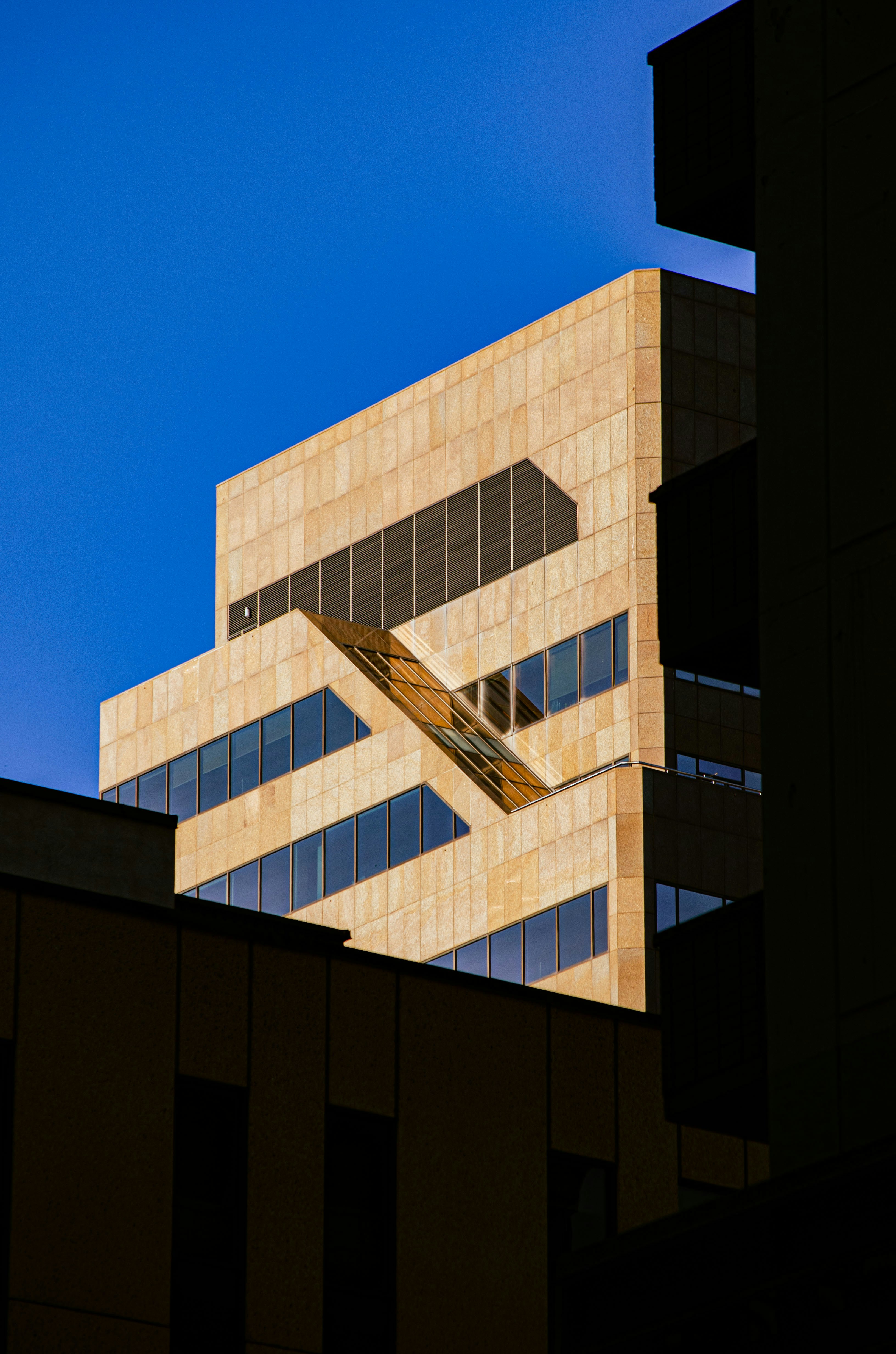 Modern beige building against a clear blue sky