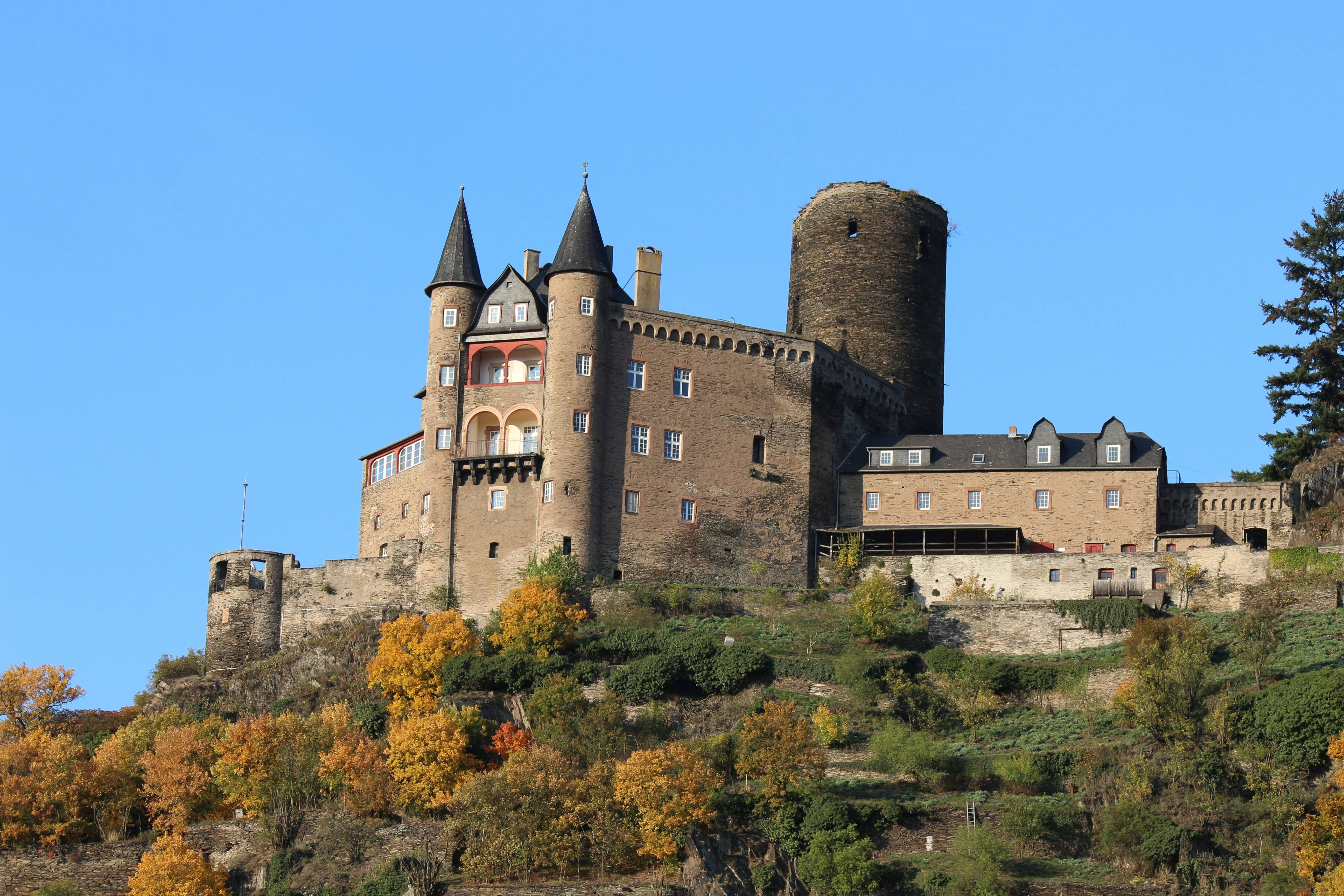 Historic castle perched on a hill with autumn trees
