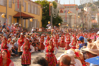 People in traditional costumes marching in a street parade.