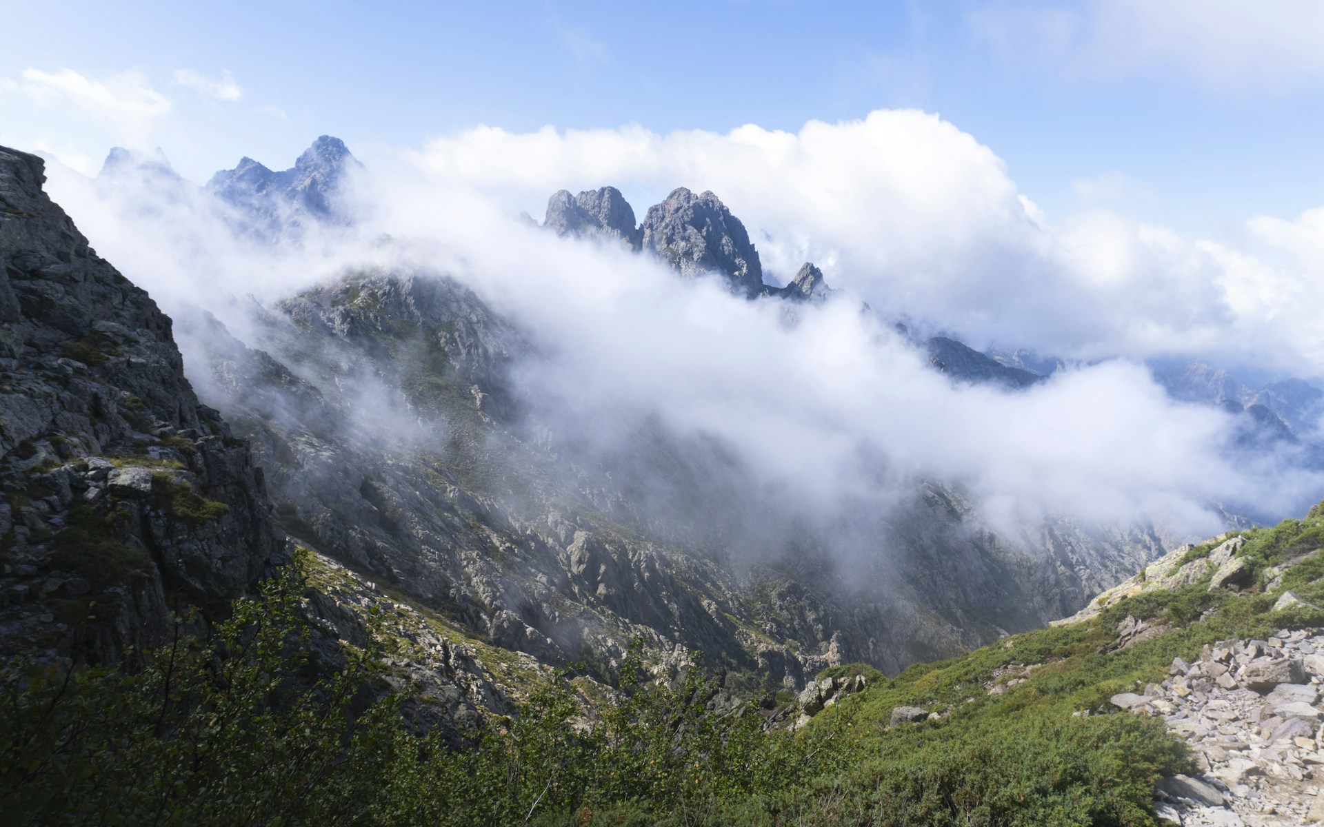 Misty mountain peaks under a cloudy sky.
