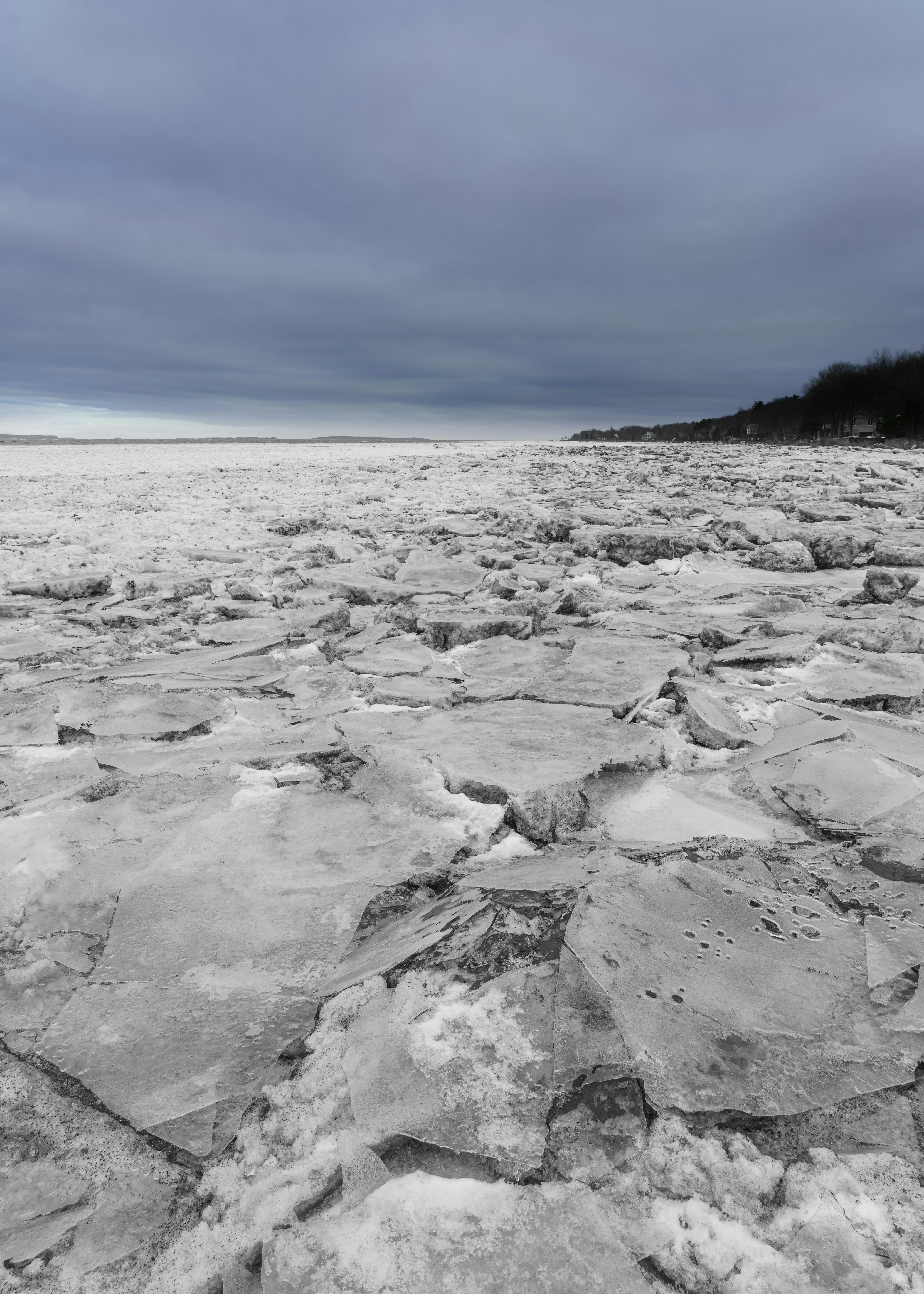 Cracked ice surface under a cloudy sky