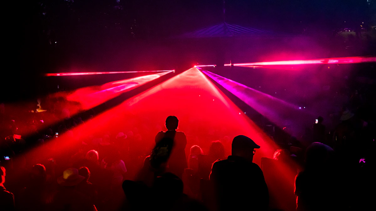 Red laser beams sweeping above a concert audience