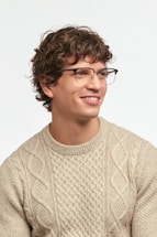 Man with curly hair wearing glasses and sweater