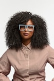Woman with curly hair wearing glasses and striped shirt