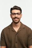 Man with glasses smiling against a white background