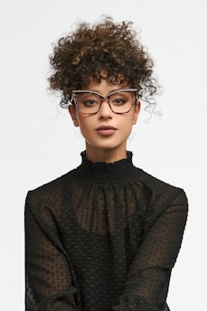 Woman with curly hair wearing glasses and black shirt
