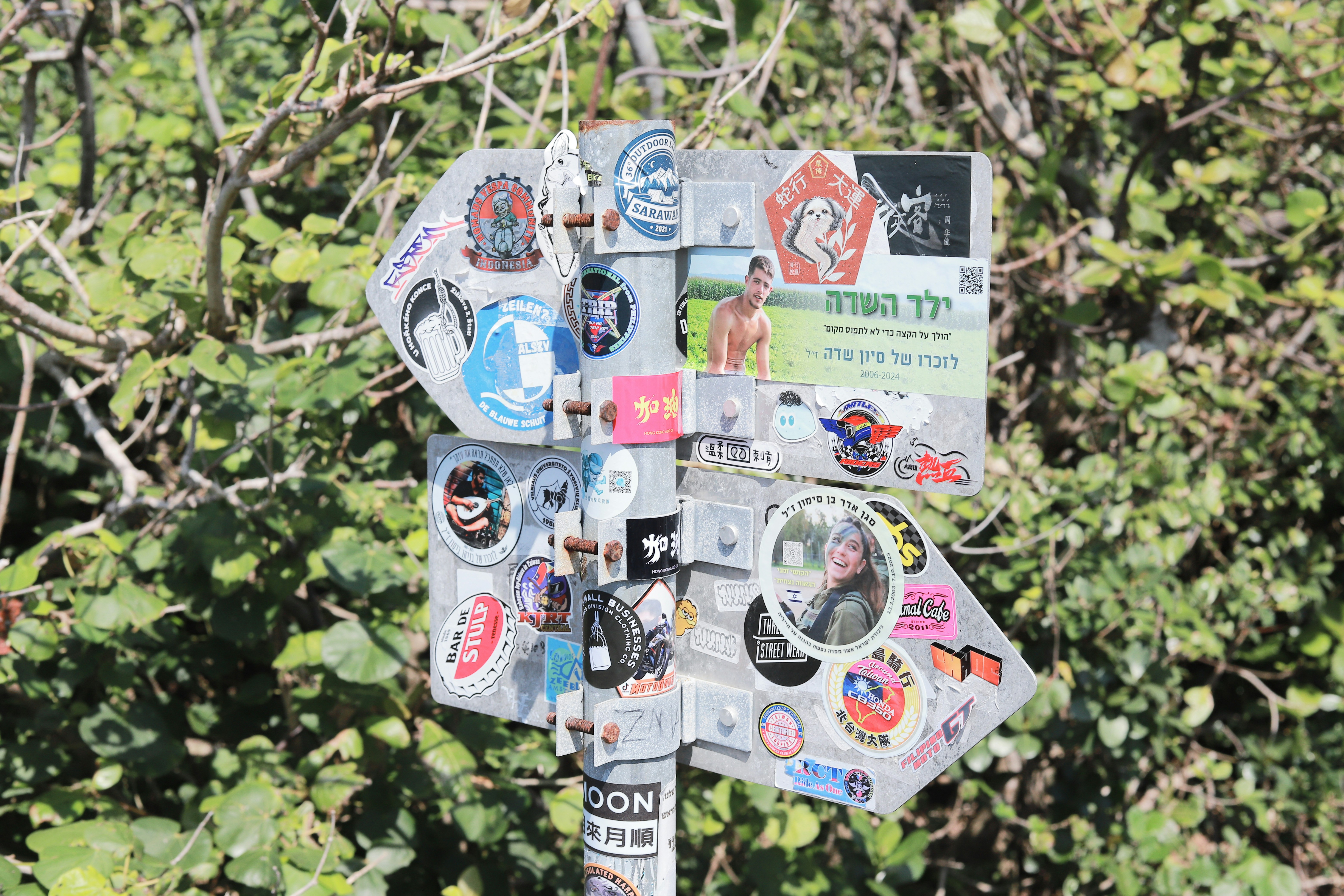 Signpost covered in stickers with greenery