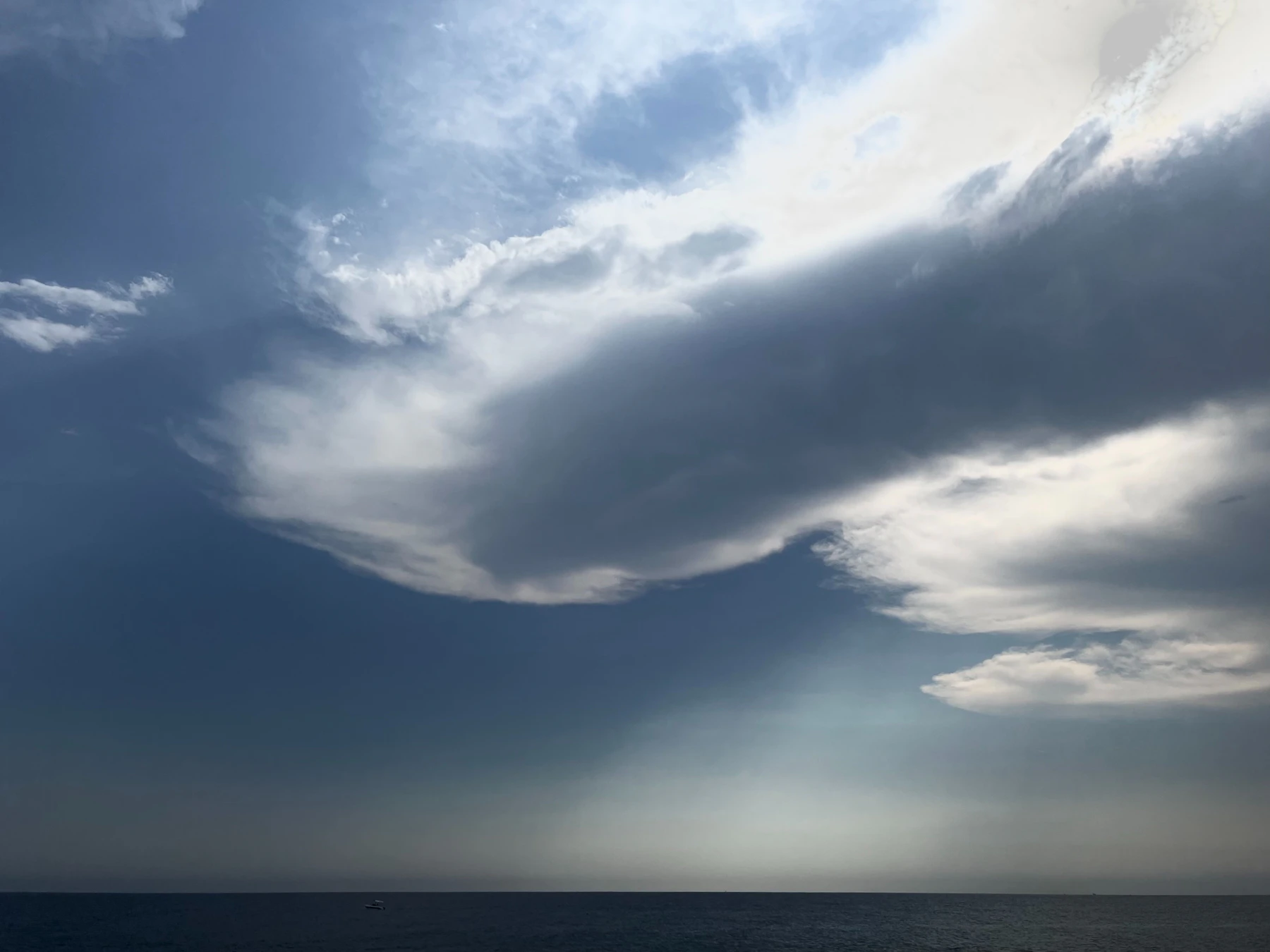 Dramatic clouds over a vast dark ocean horizon