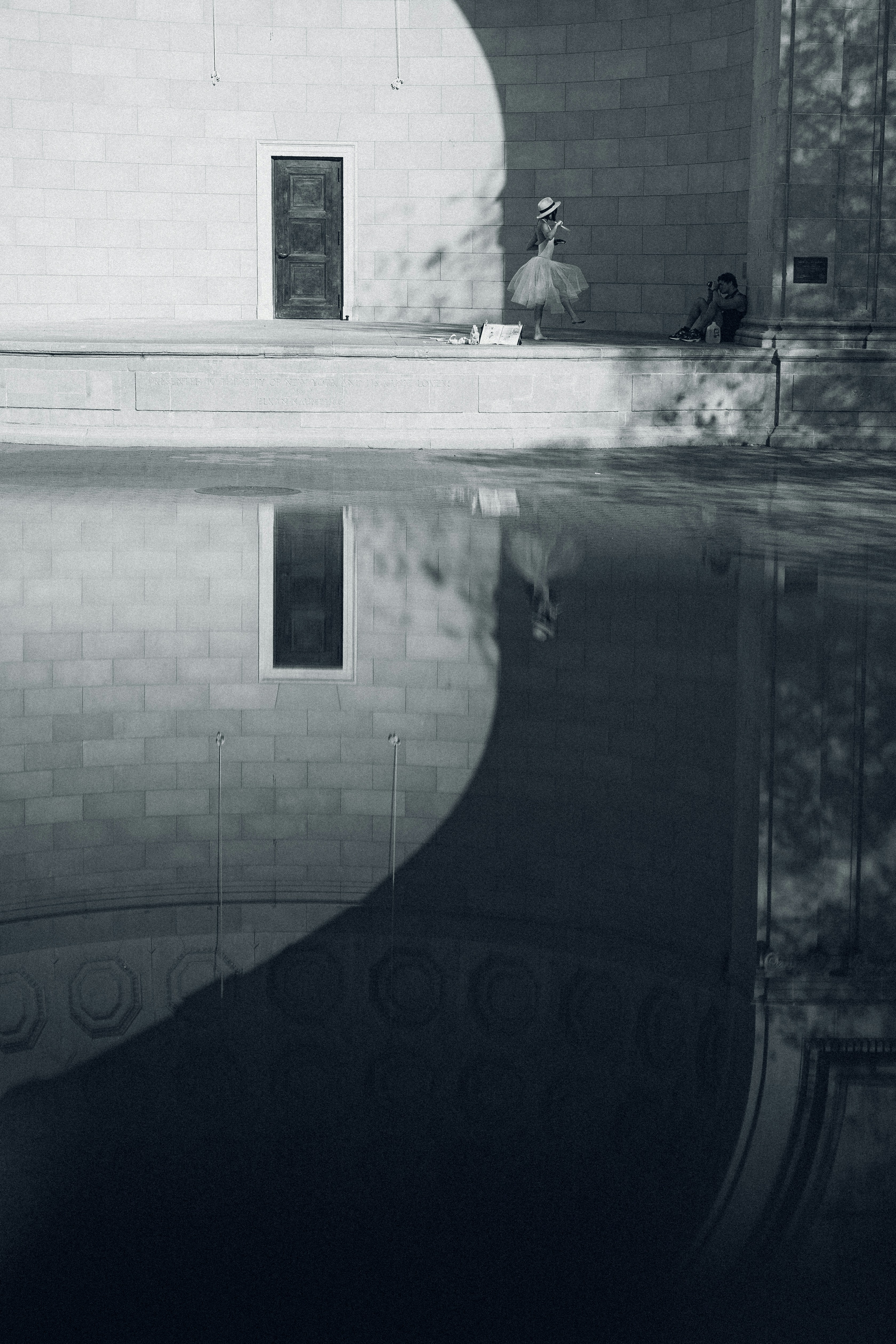 Bailarina com chapéu de palha refletido na água