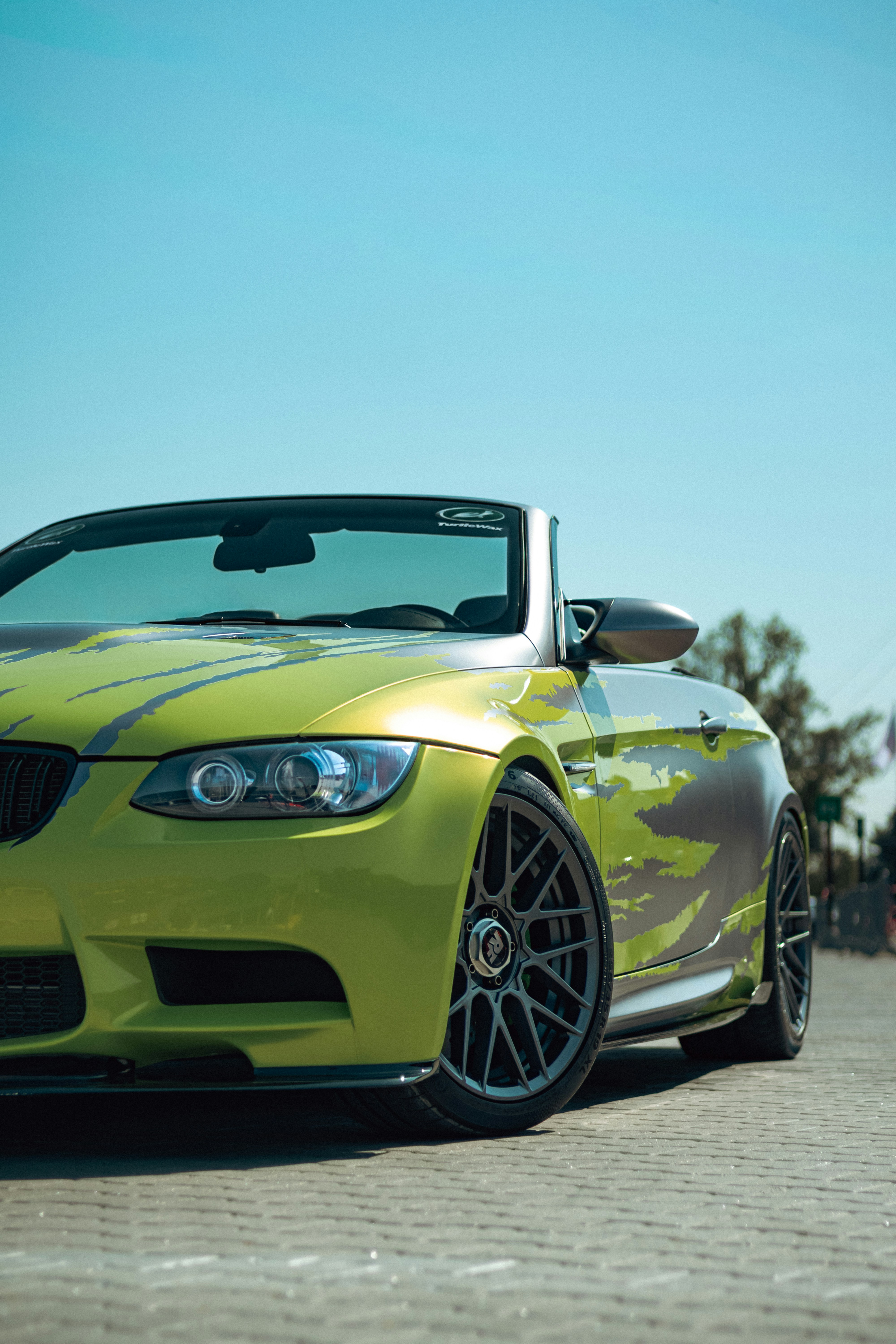 Lime green convertible sports car parked on pavement.