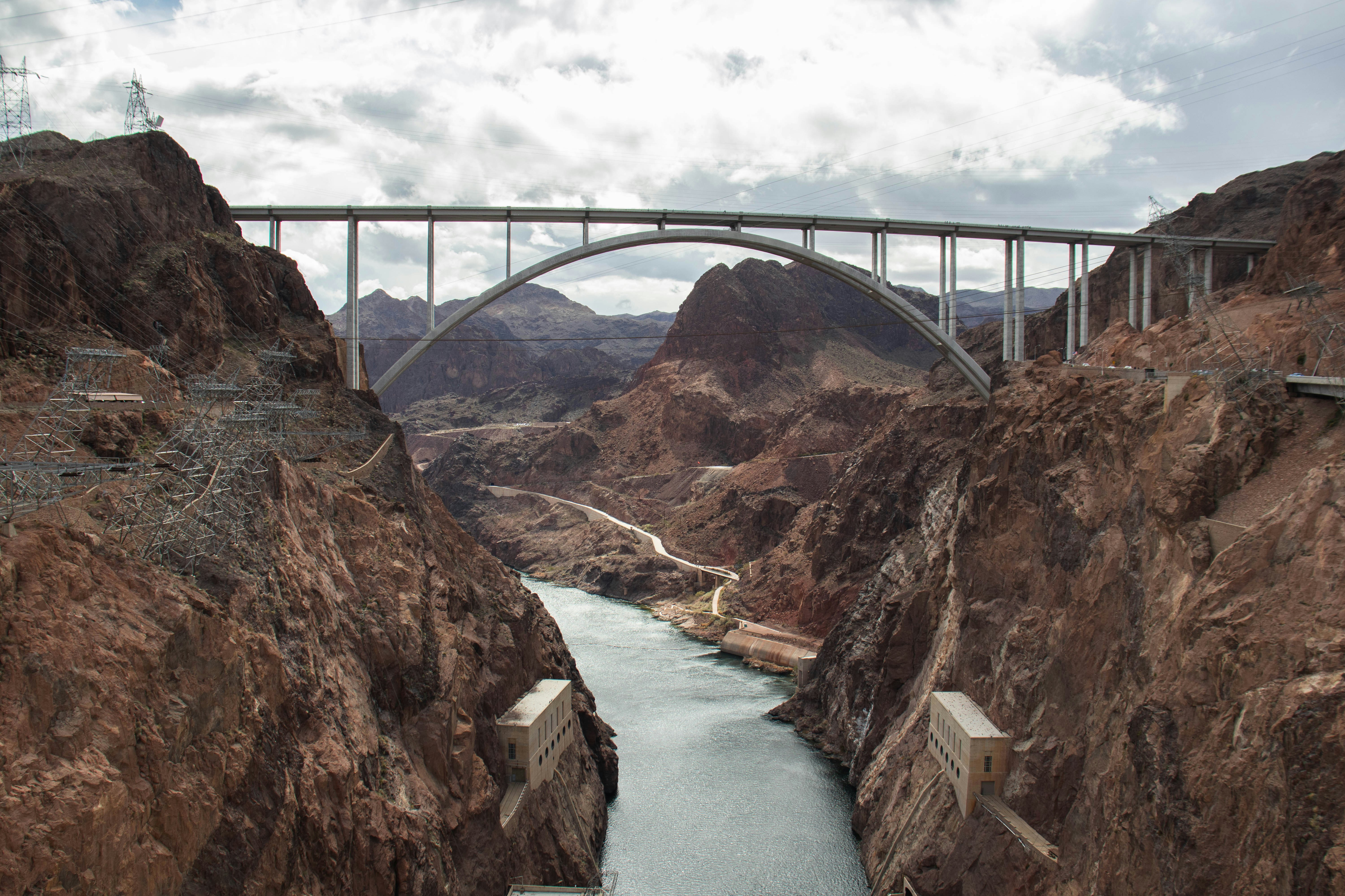 Arch bridge spans a river between rocky canyons