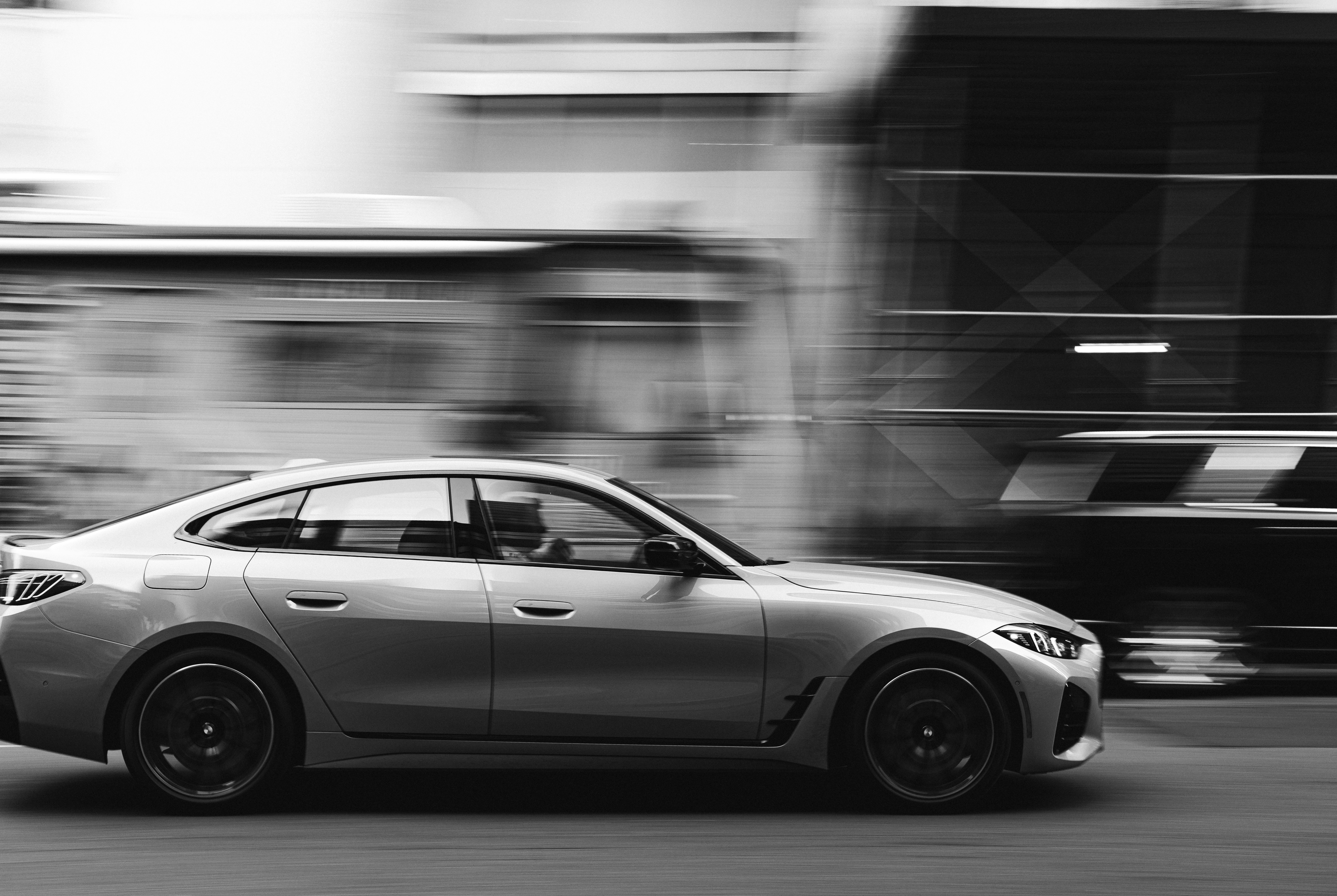 Carro prateado dirigindo rápido na rua da cidade