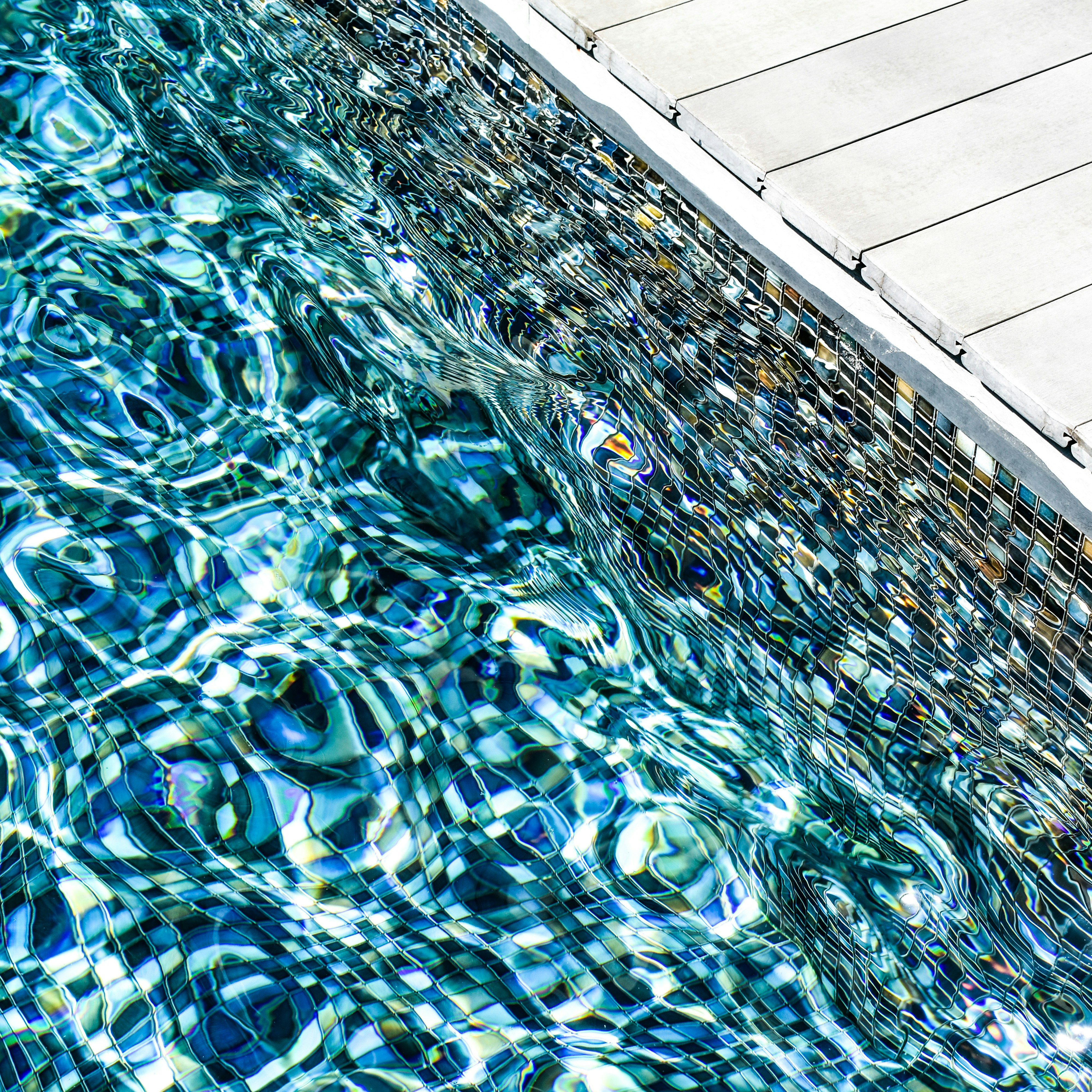 on the edge of a tiled swimming pool