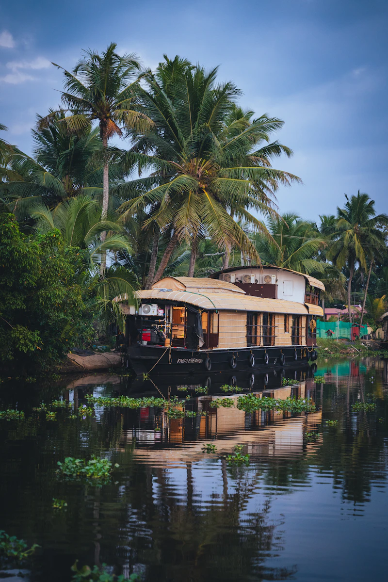 Houseboat moored on a tranquil palm-lined waterway in Kerala