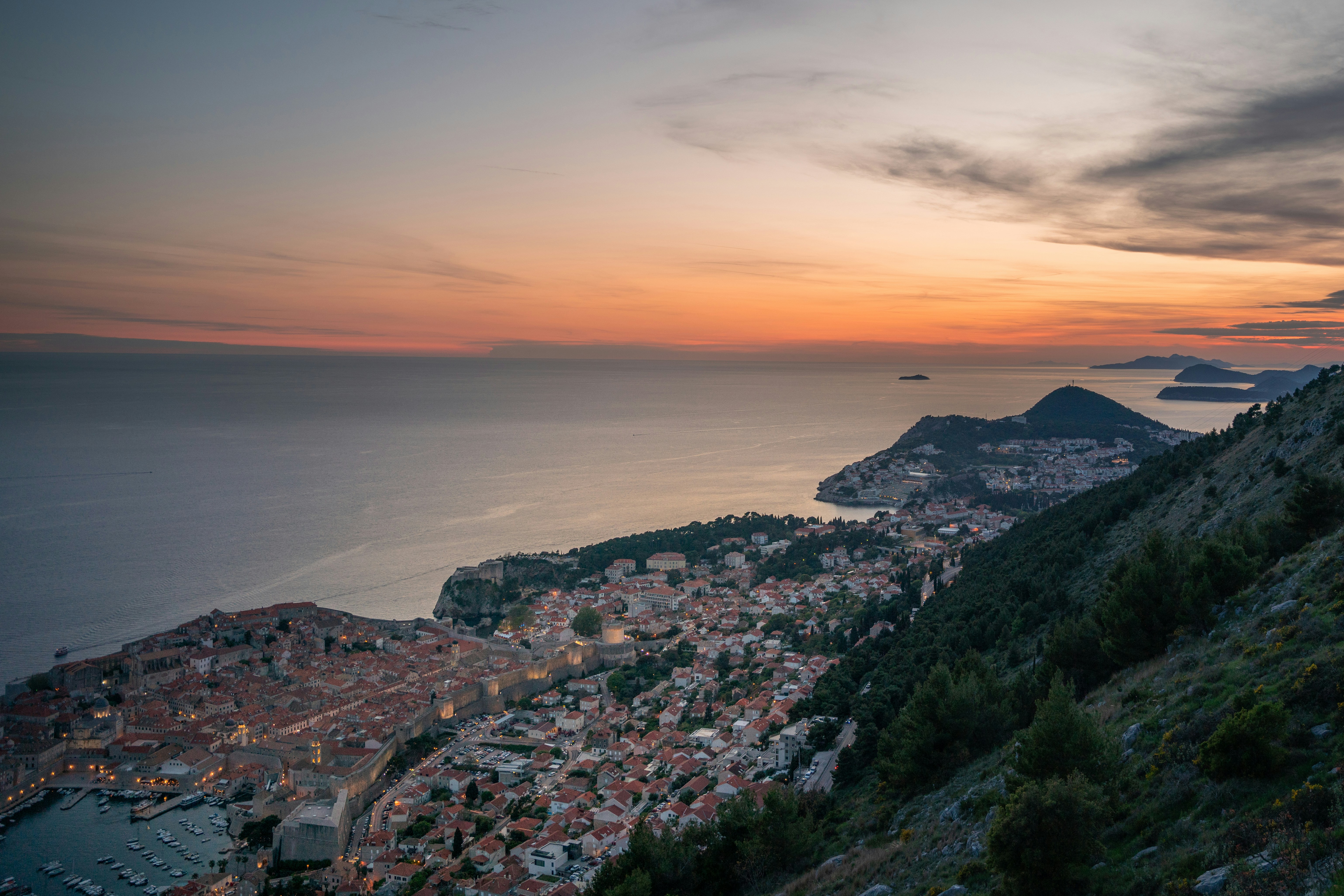 Coastal city nestled between mountains and sea at sunset